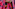 Hands holding beads and staff, draped in vibrant pink Maasai plaid shuka.