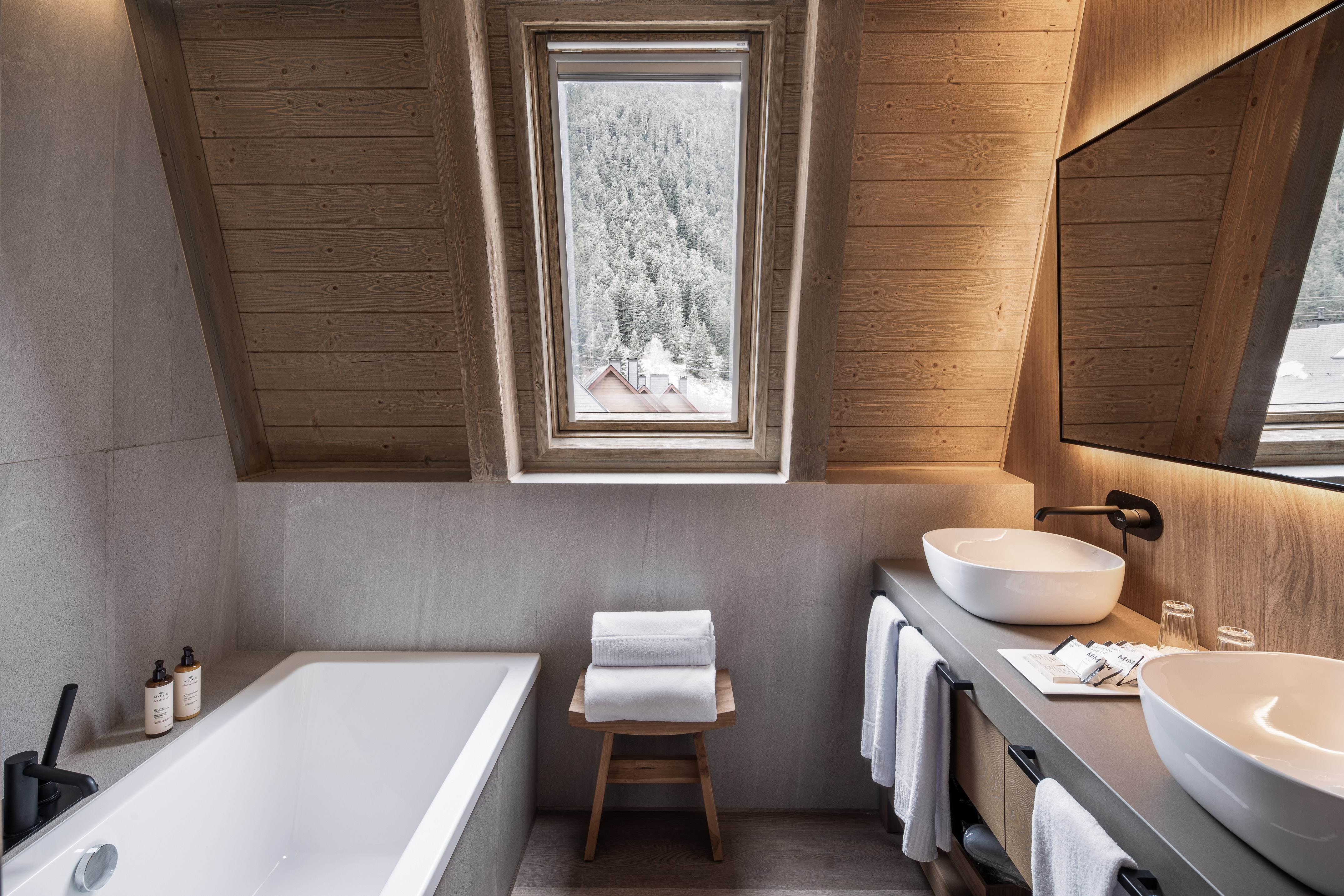 Modern bathroom wood ceiling bathtub dual sinks snowy mountain view