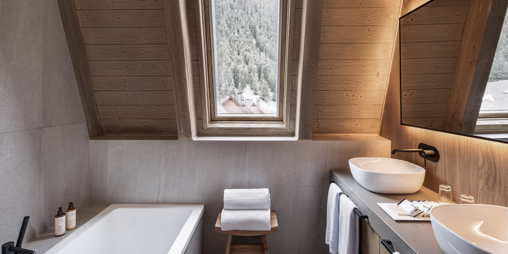 Modern bathroom wood ceiling bathtub dual sinks snowy mountain view