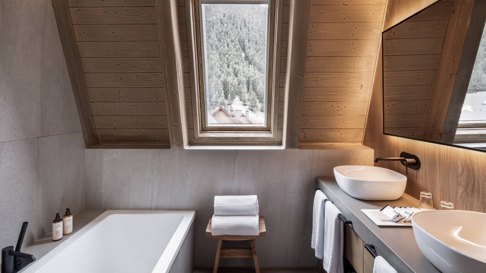 Modern bathroom wood ceiling bathtub dual sinks snowy mountain view