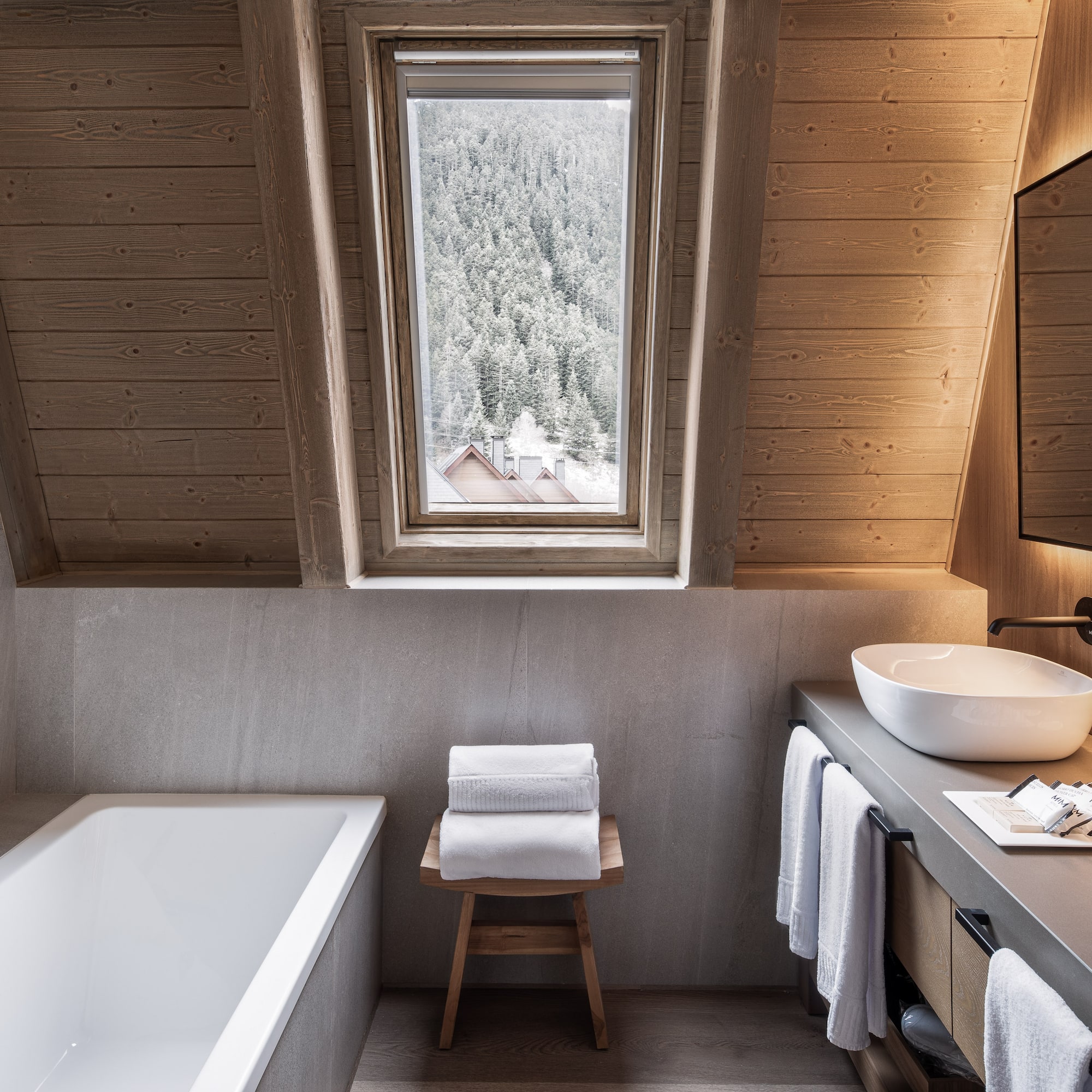 Modern bathroom wood ceiling bathtub dual sinks snowy mountain view