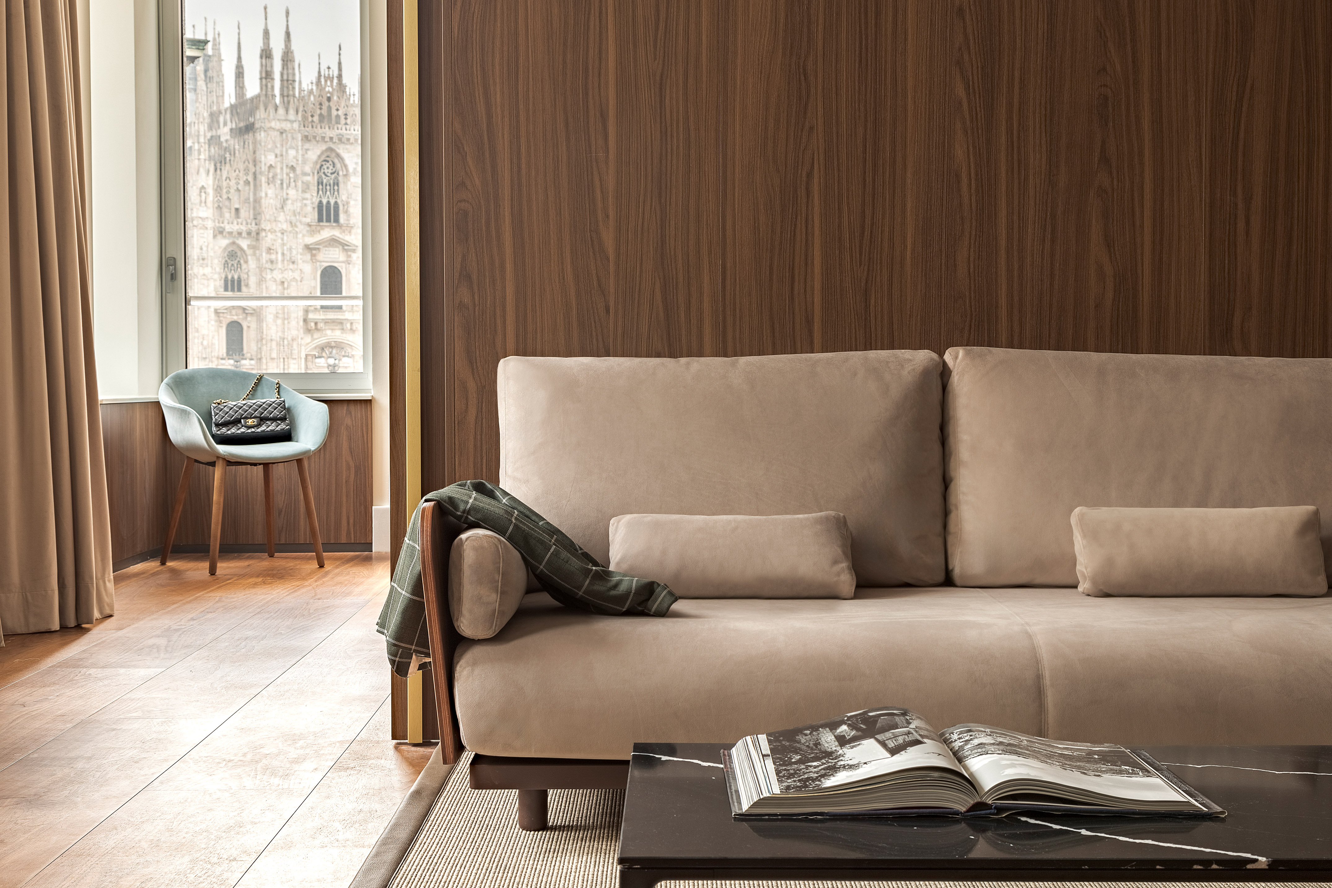 Modern beige sofa in luxury living room with Milan Duomo view.
