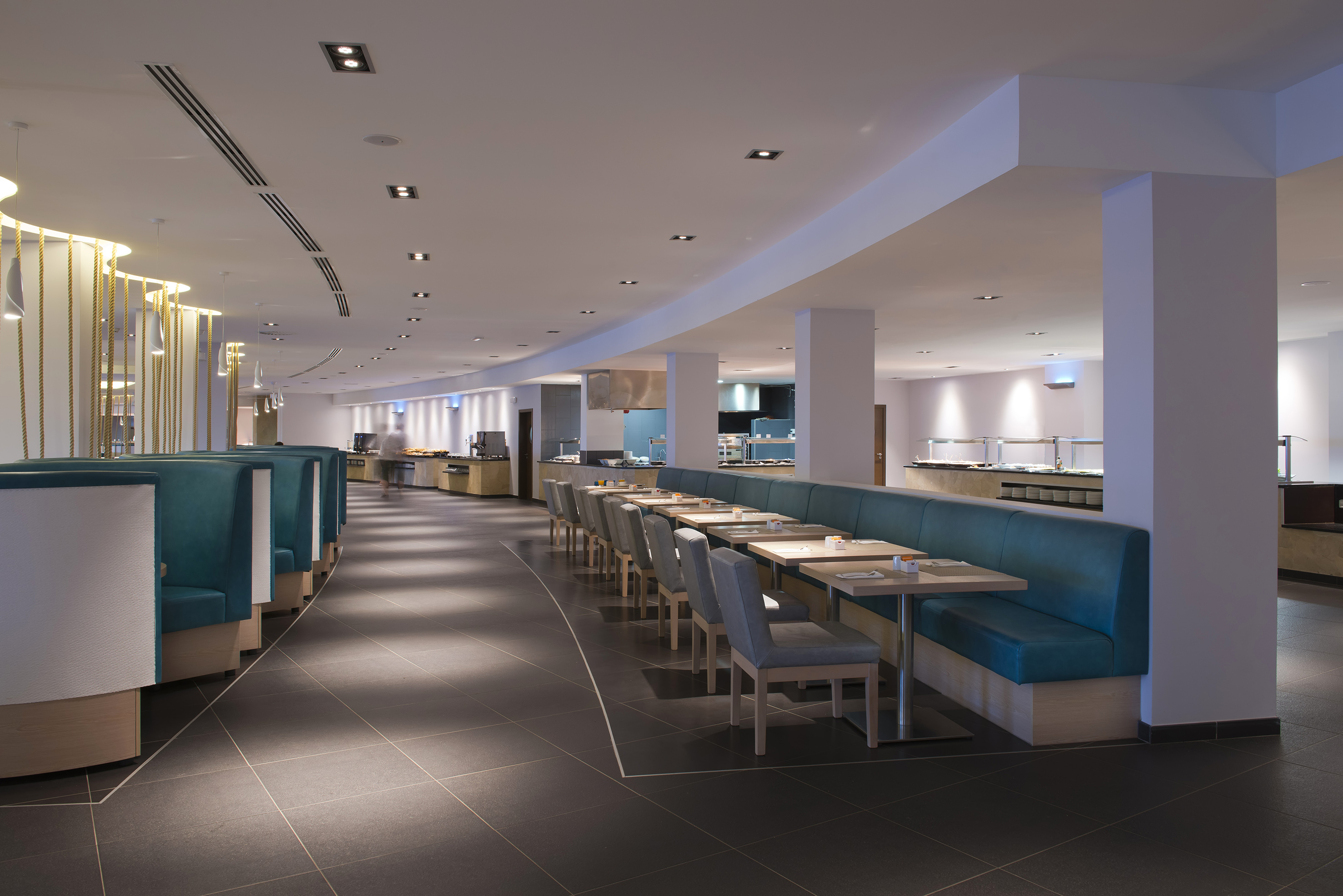 a restaurant with blue booth seating and blue chairs