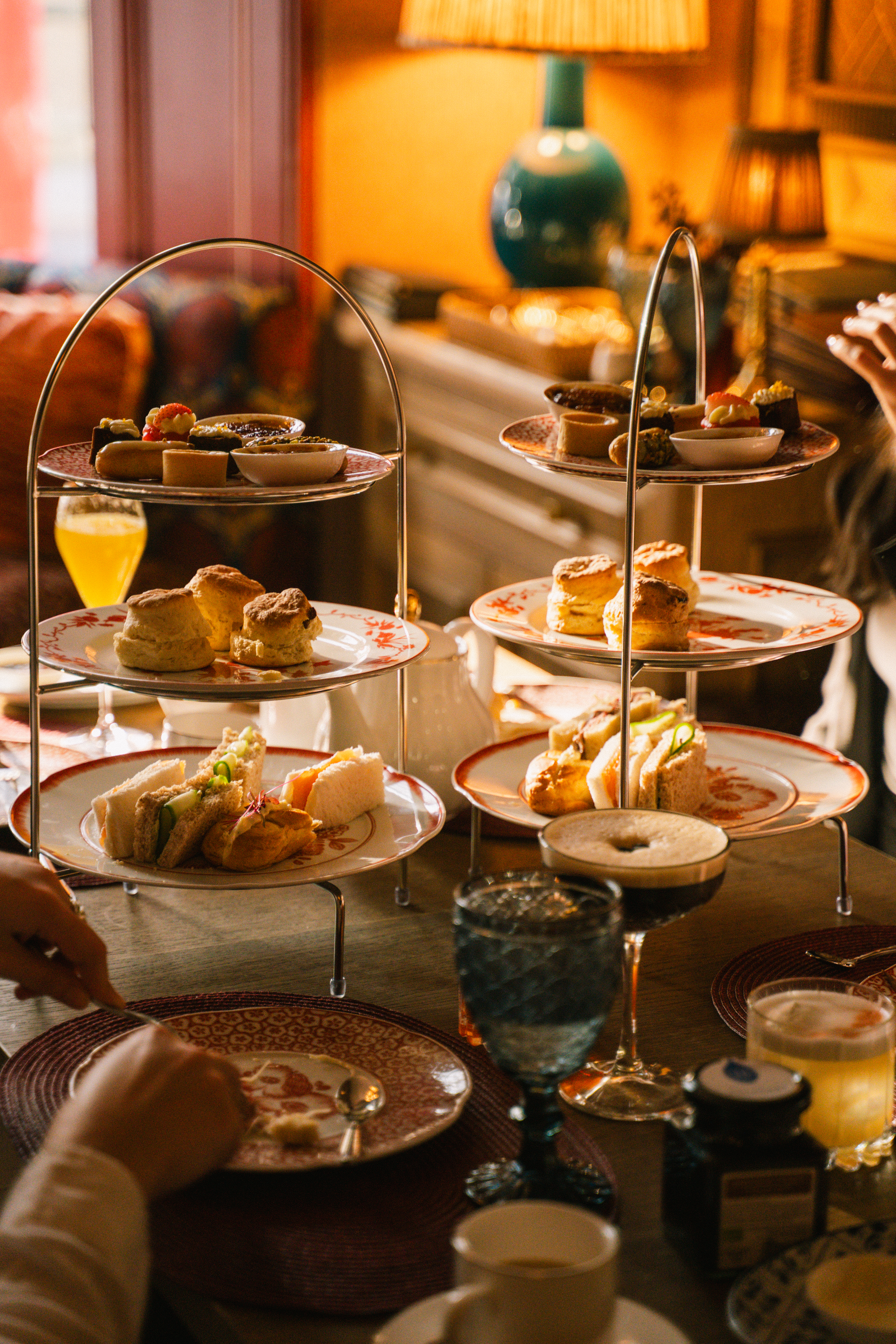 Elegant afternoon tea with scones, sandwiches, and desserts on tiered stands.