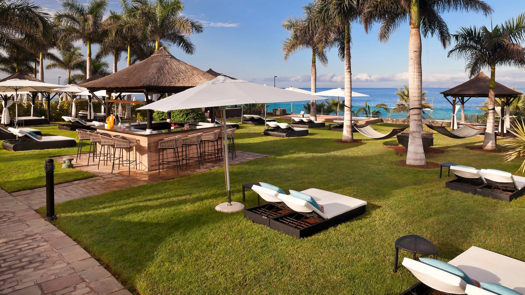 a beach bar with chairs and umbrellas
