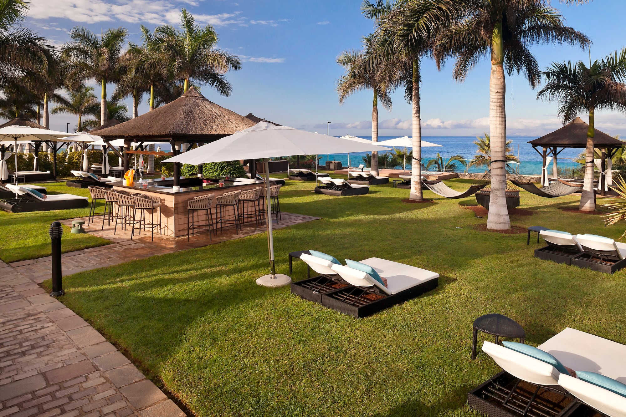 a beach bar with chairs and umbrellas