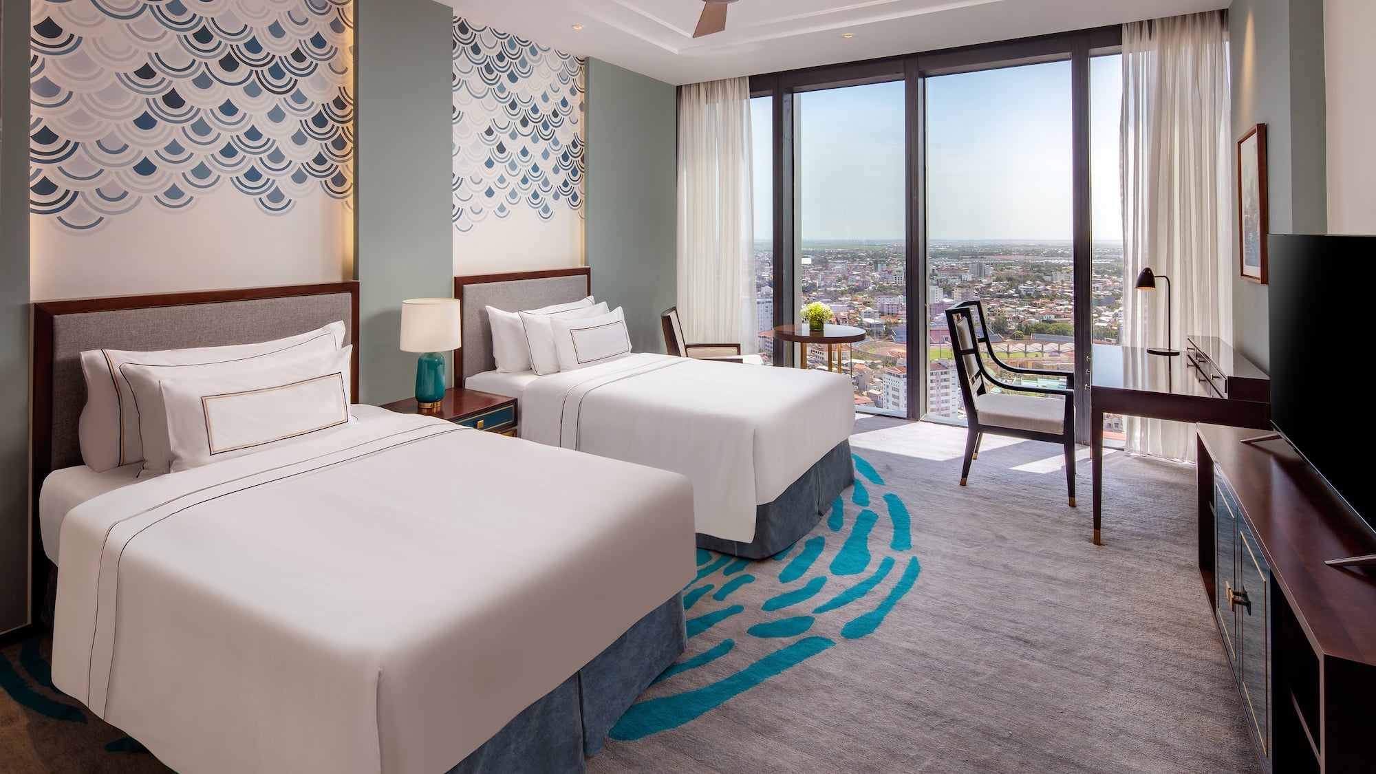 a room with two beds and a table and chairs