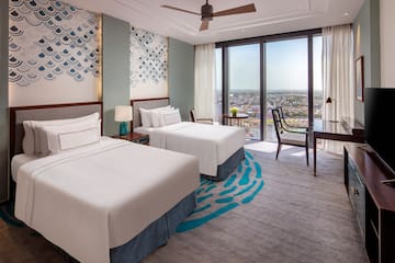 a room with two beds and a table and chairs