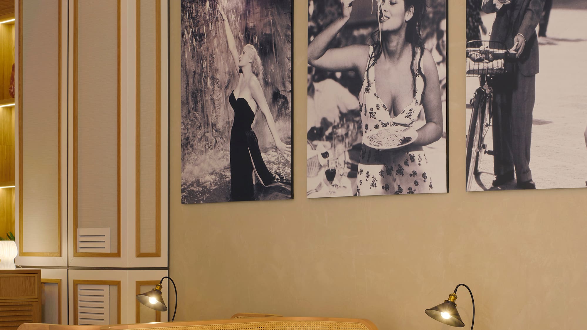 a room with a table and chairs and a table with a couple of pictures on the wall