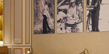 a room with a table and chairs and a table with a couple of pictures on the wall