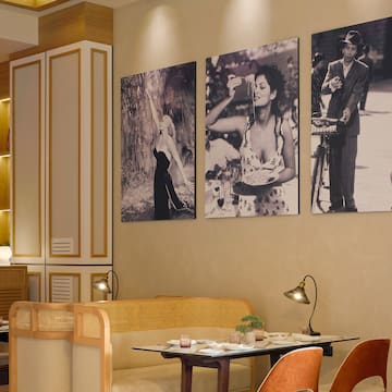 a room with a table and chairs and a table with a couple of pictures on the wall