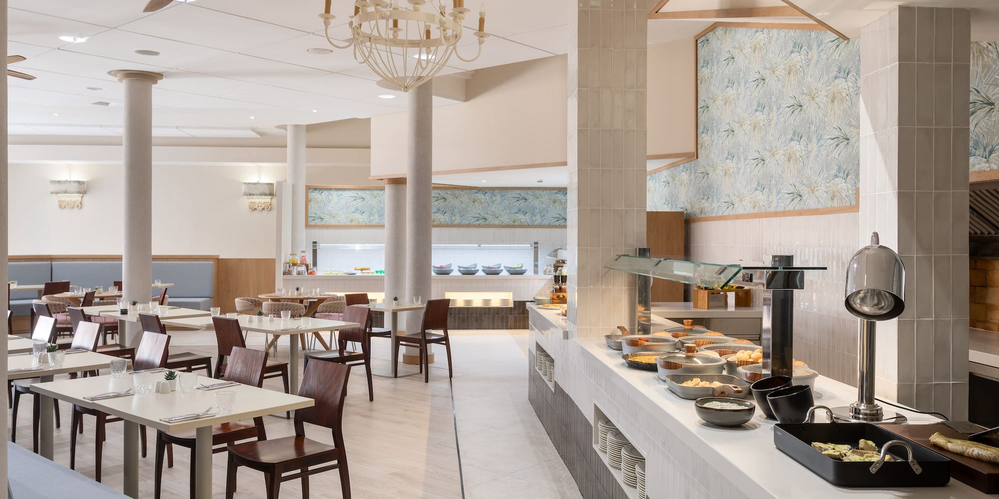 Hotel dining room with breakfast buffet, modern decor, and tables.