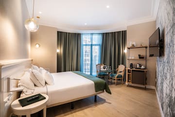 a room with a bed and chairs