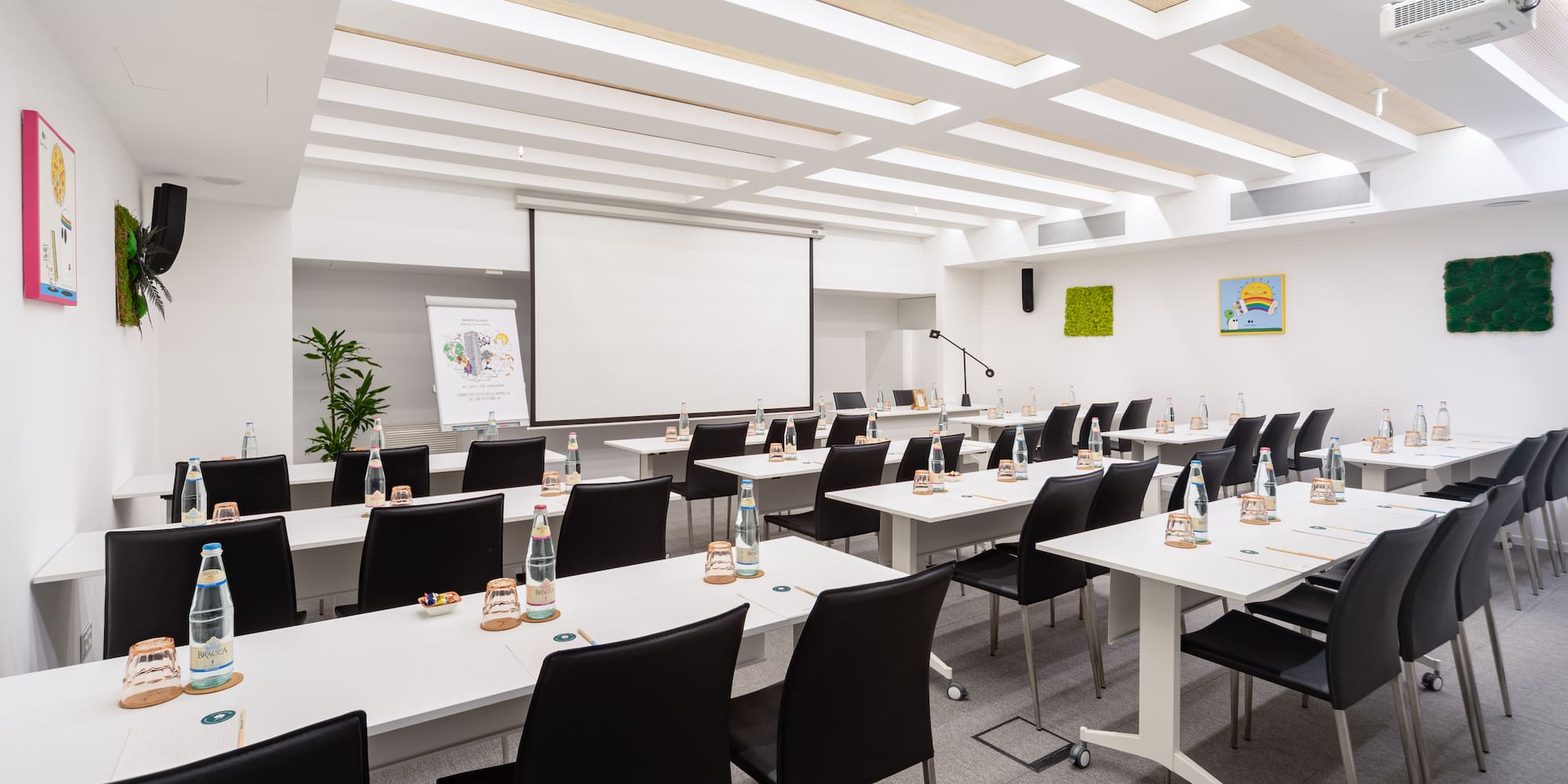 a room with white tables and black chairs