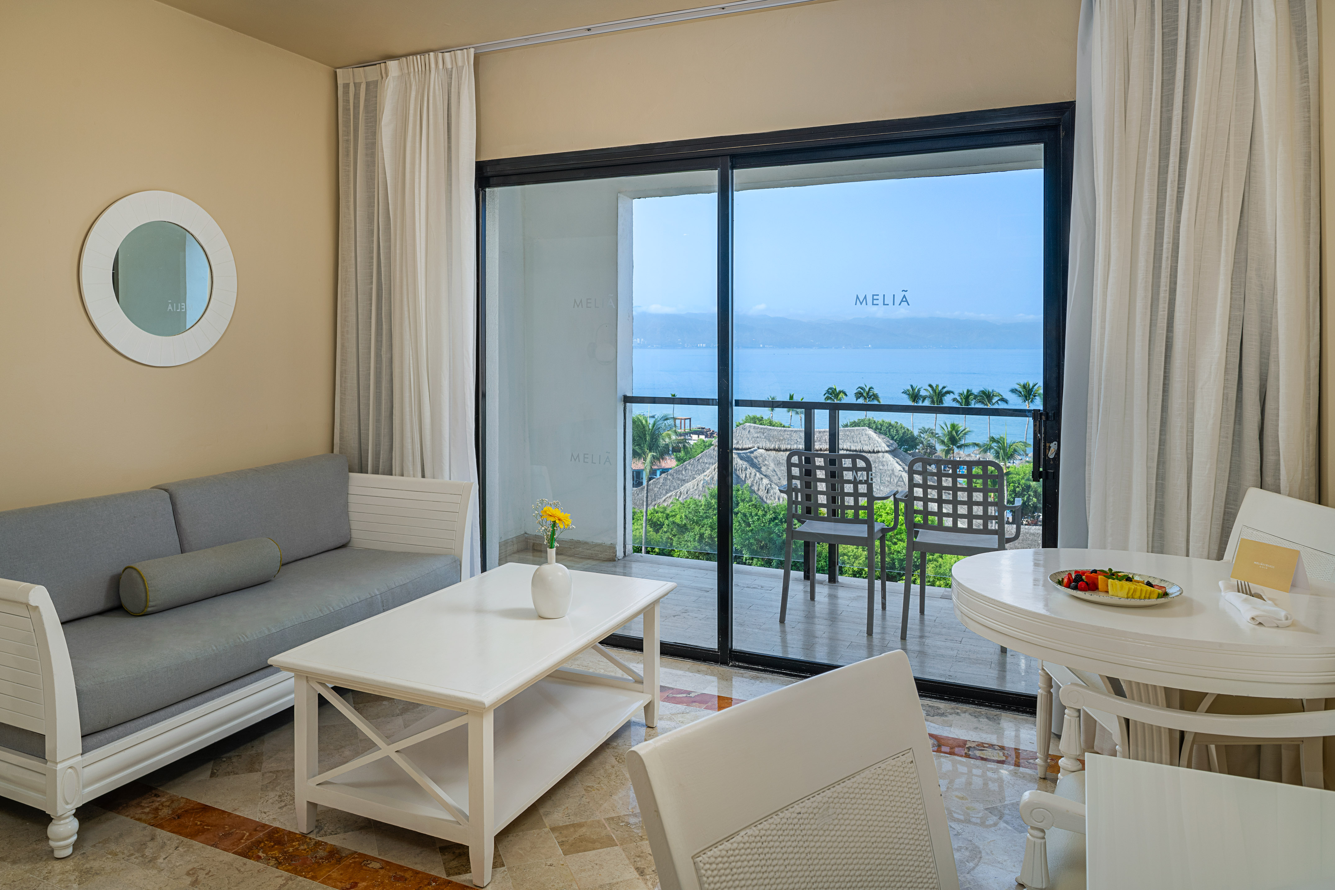 Melia hotel suite with ocean view balcony, living and dining area.