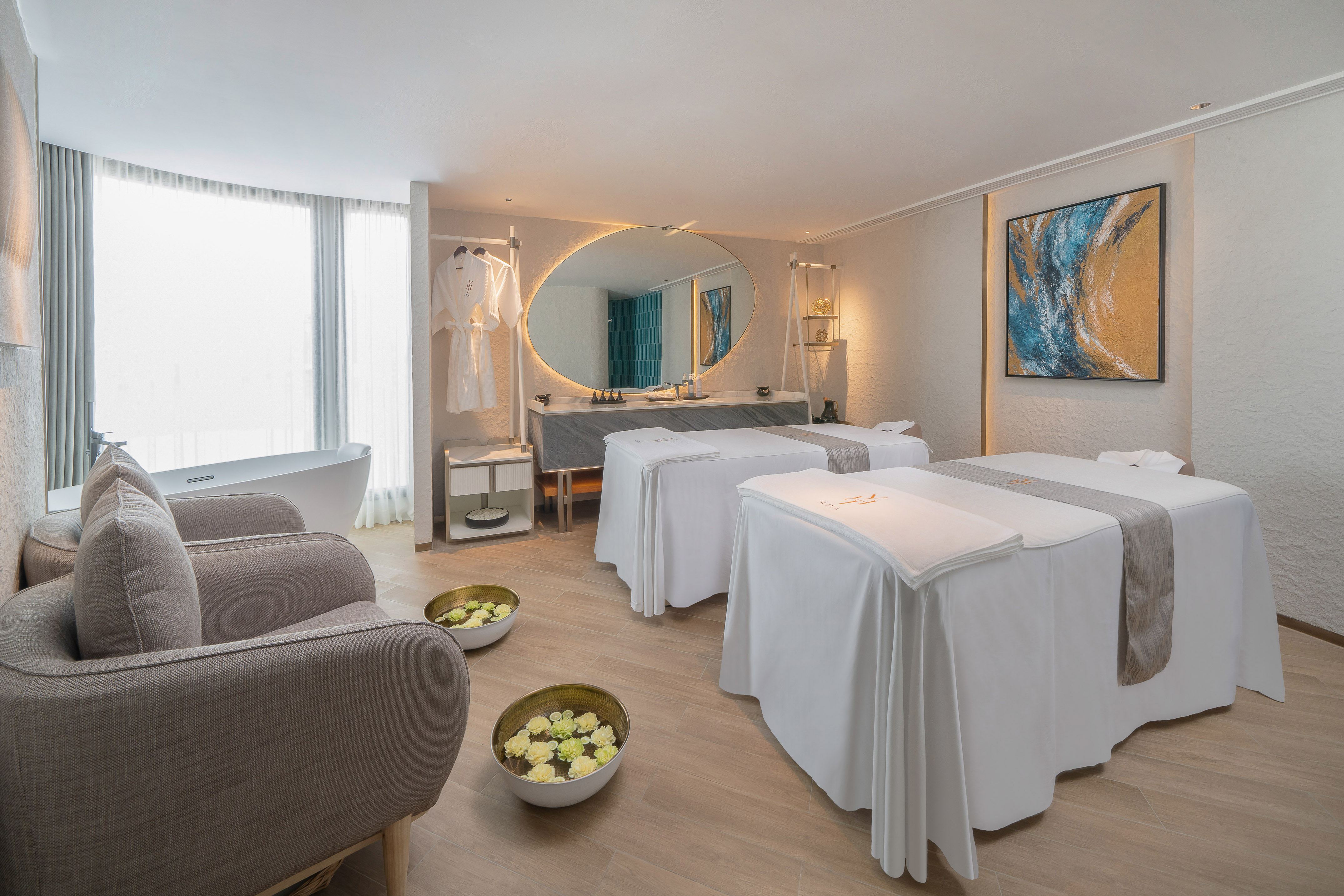 a room with white beds and a mirror