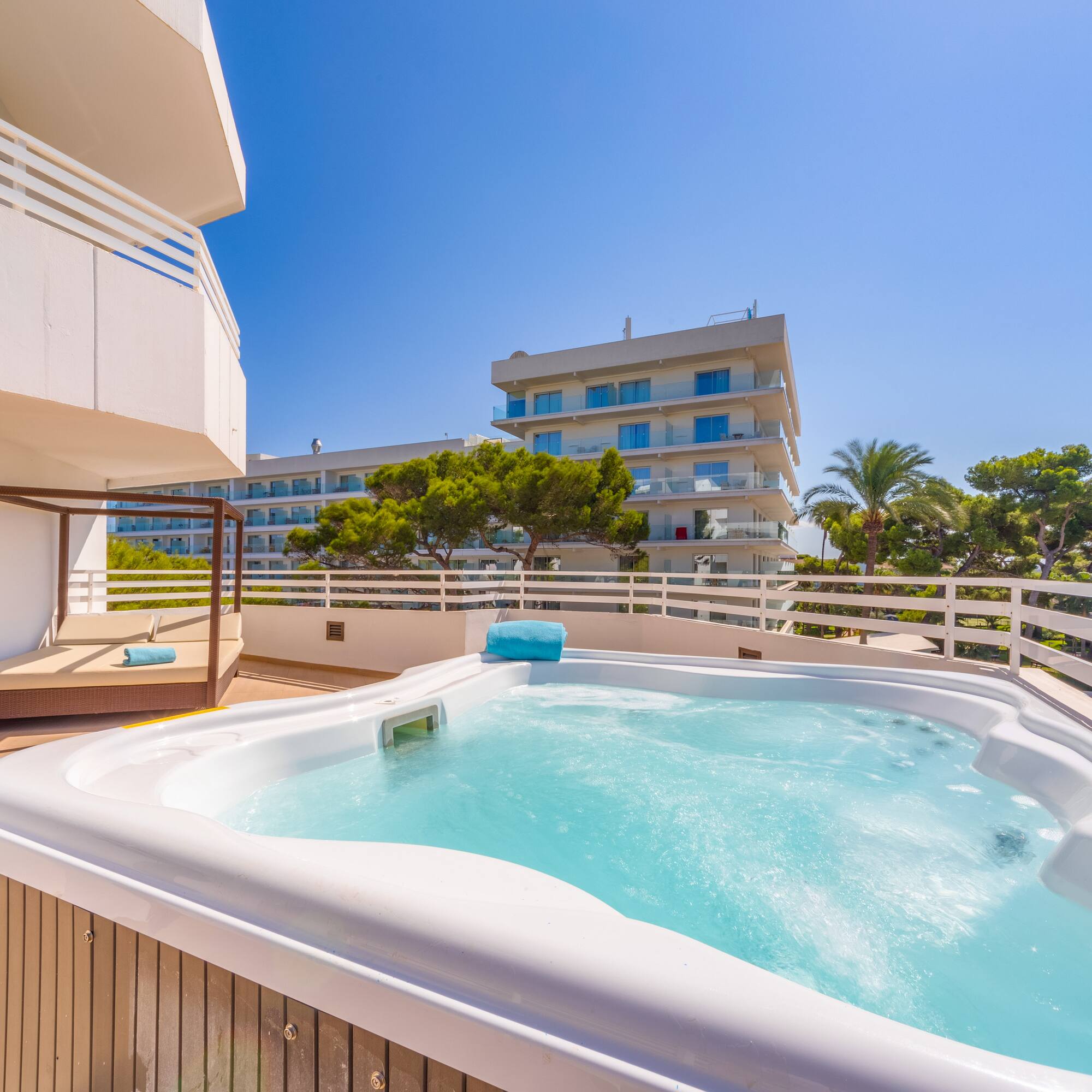 a hot tub on a deck with a balcony and trees