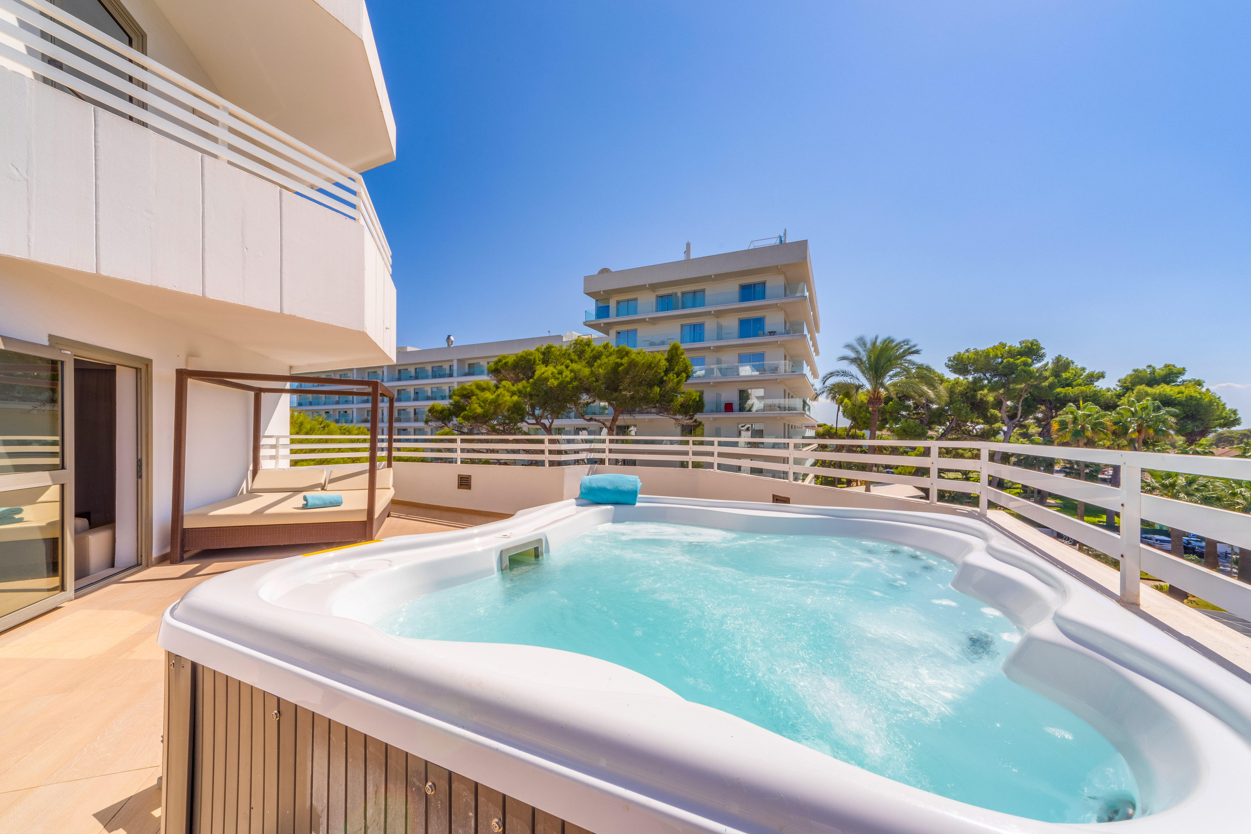 a hot tub on a deck with a balcony and trees