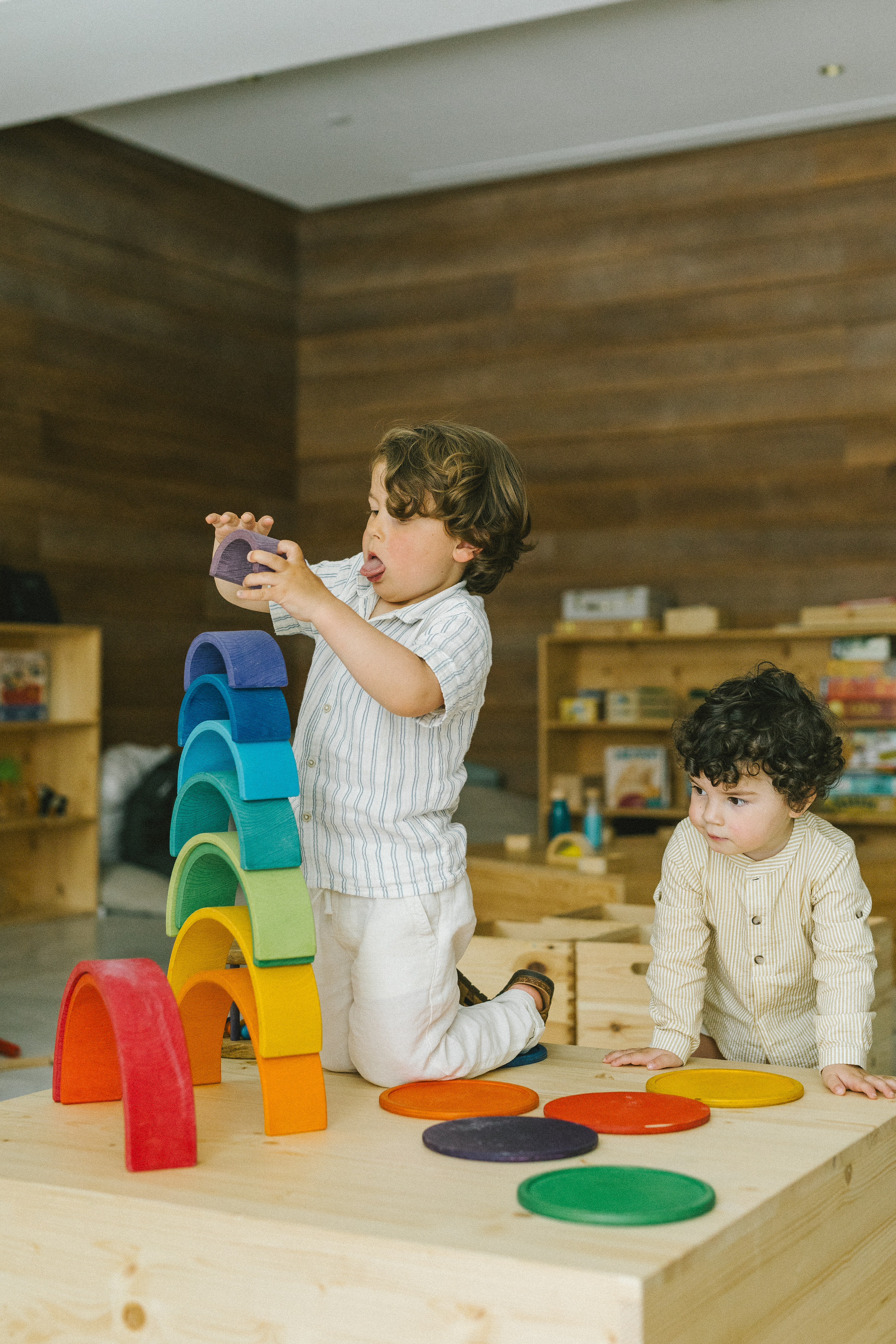 Niños jugando con arcoíris de bloques de madera, juego creativo.