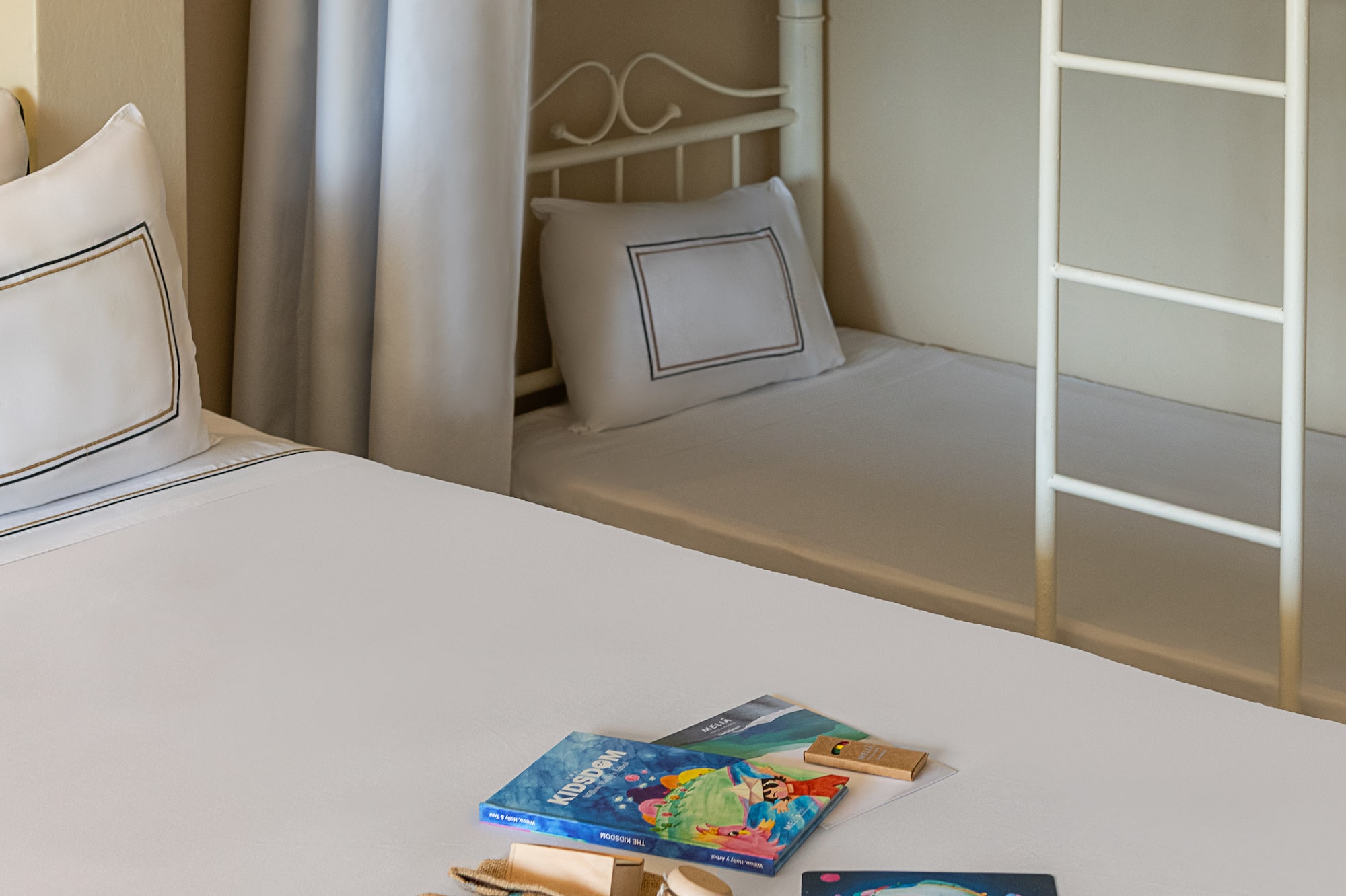 KIDSDOM books & gifts on bed, bunk bed in family hotel room.