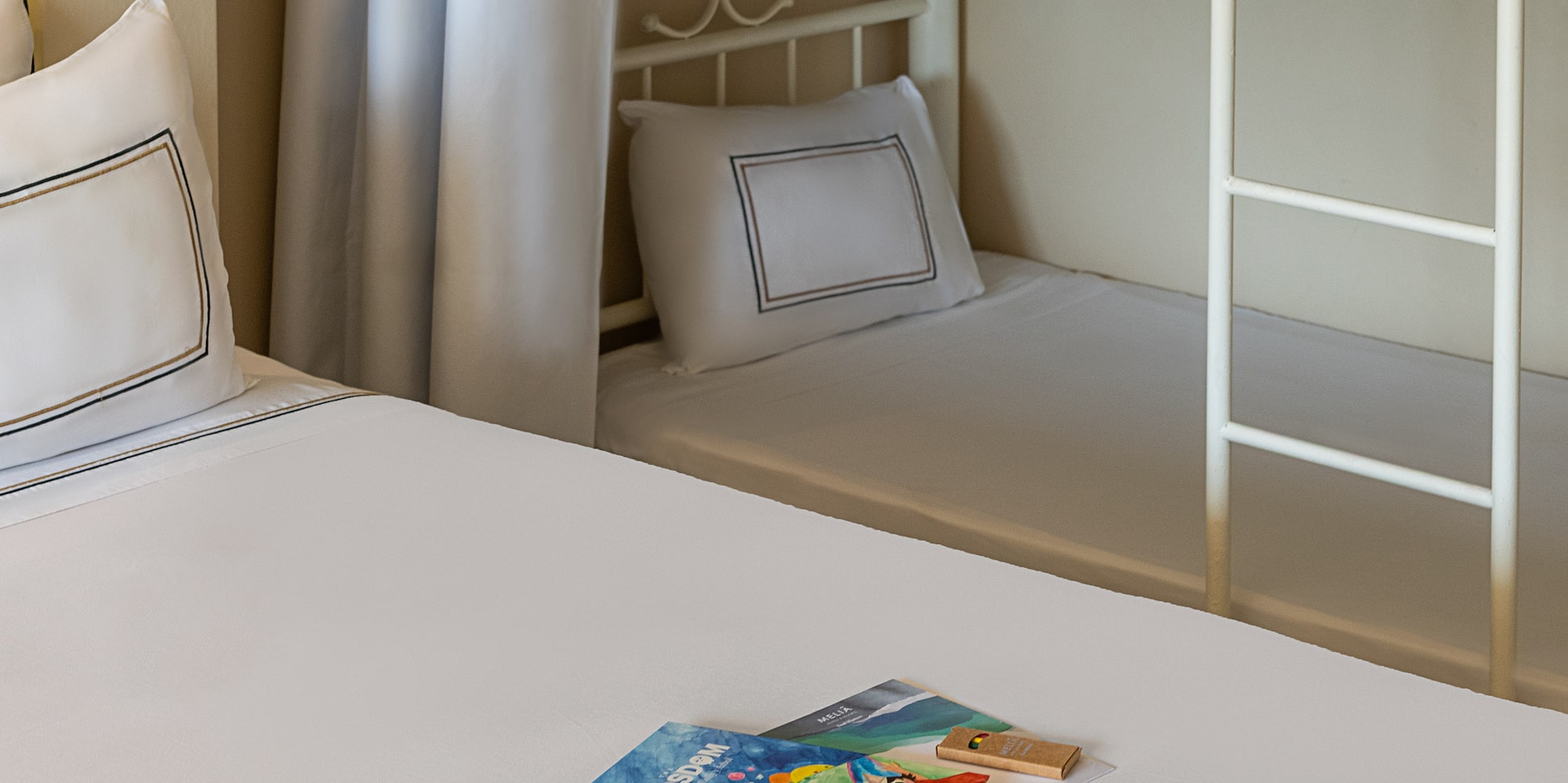 KIDSDOM books & gifts on bed, bunk bed in family hotel room.