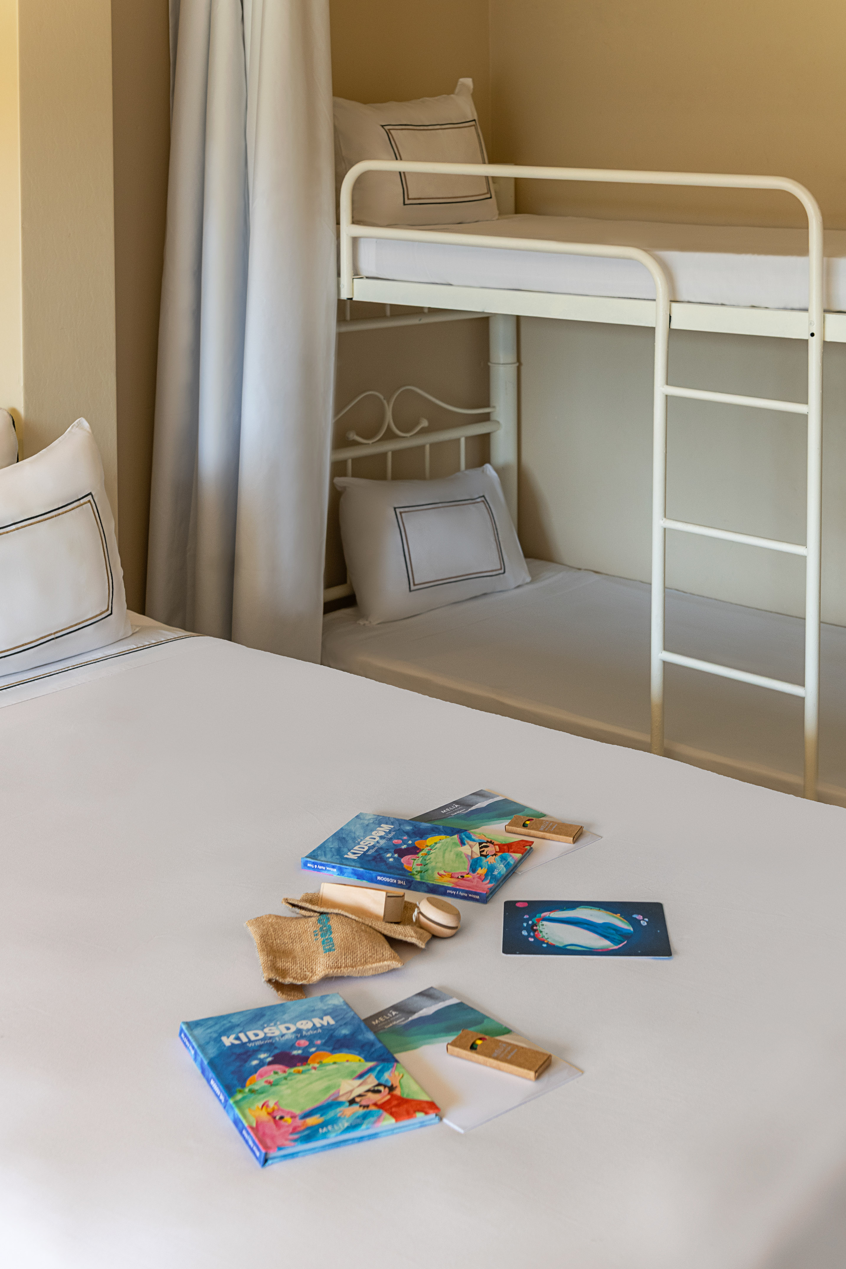 KIDSDOM books & gifts on bed, bunk bed in family hotel room.