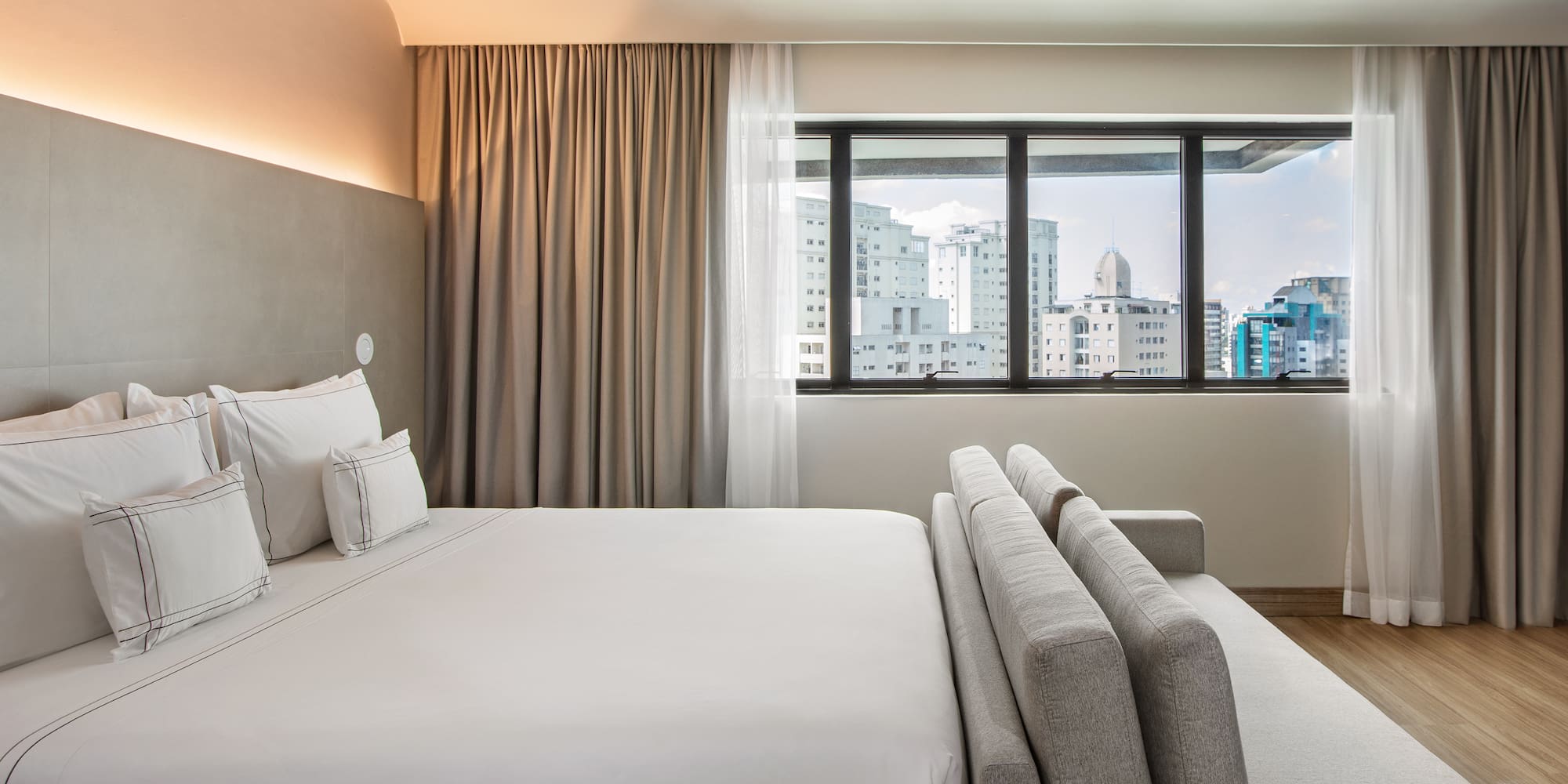 a bed in a room with a window and city view