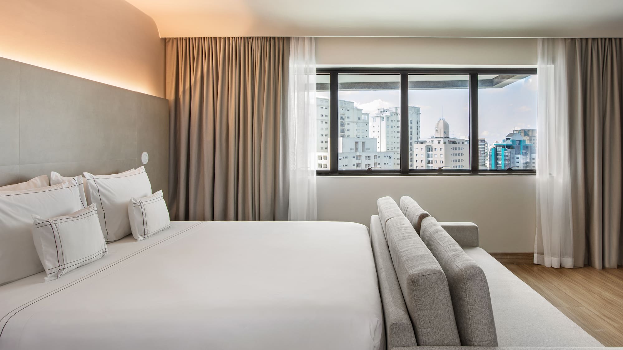 a bed in a room with a window and city view