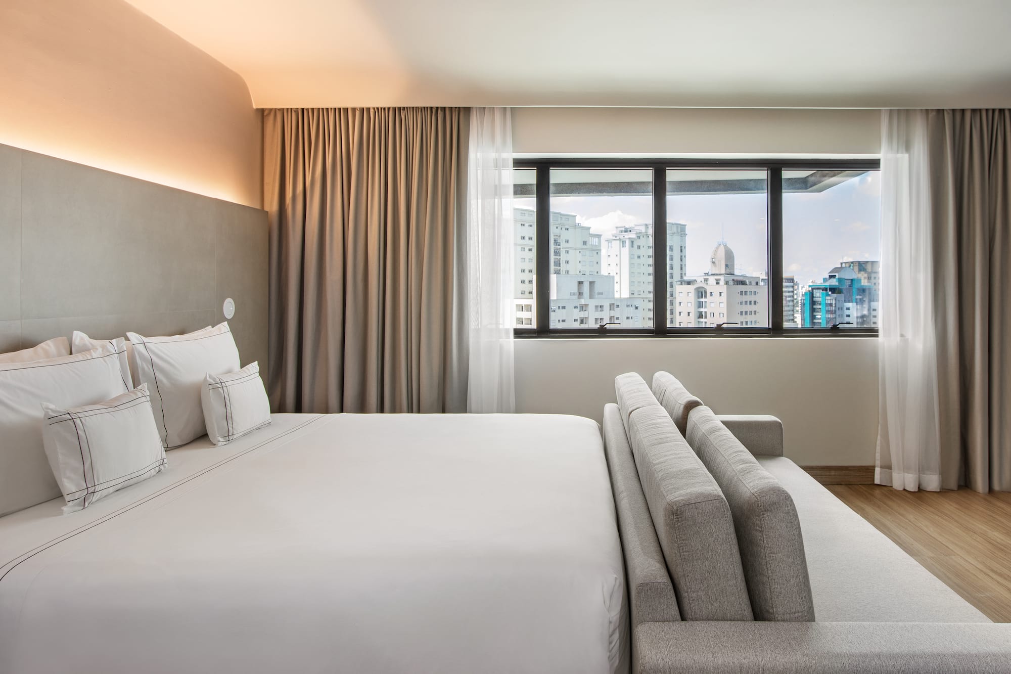 a bed in a room with a window and city view