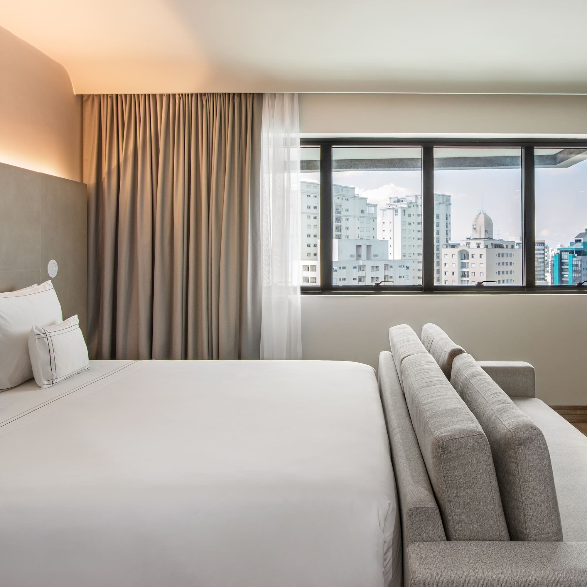 a bed in a room with a window and city view