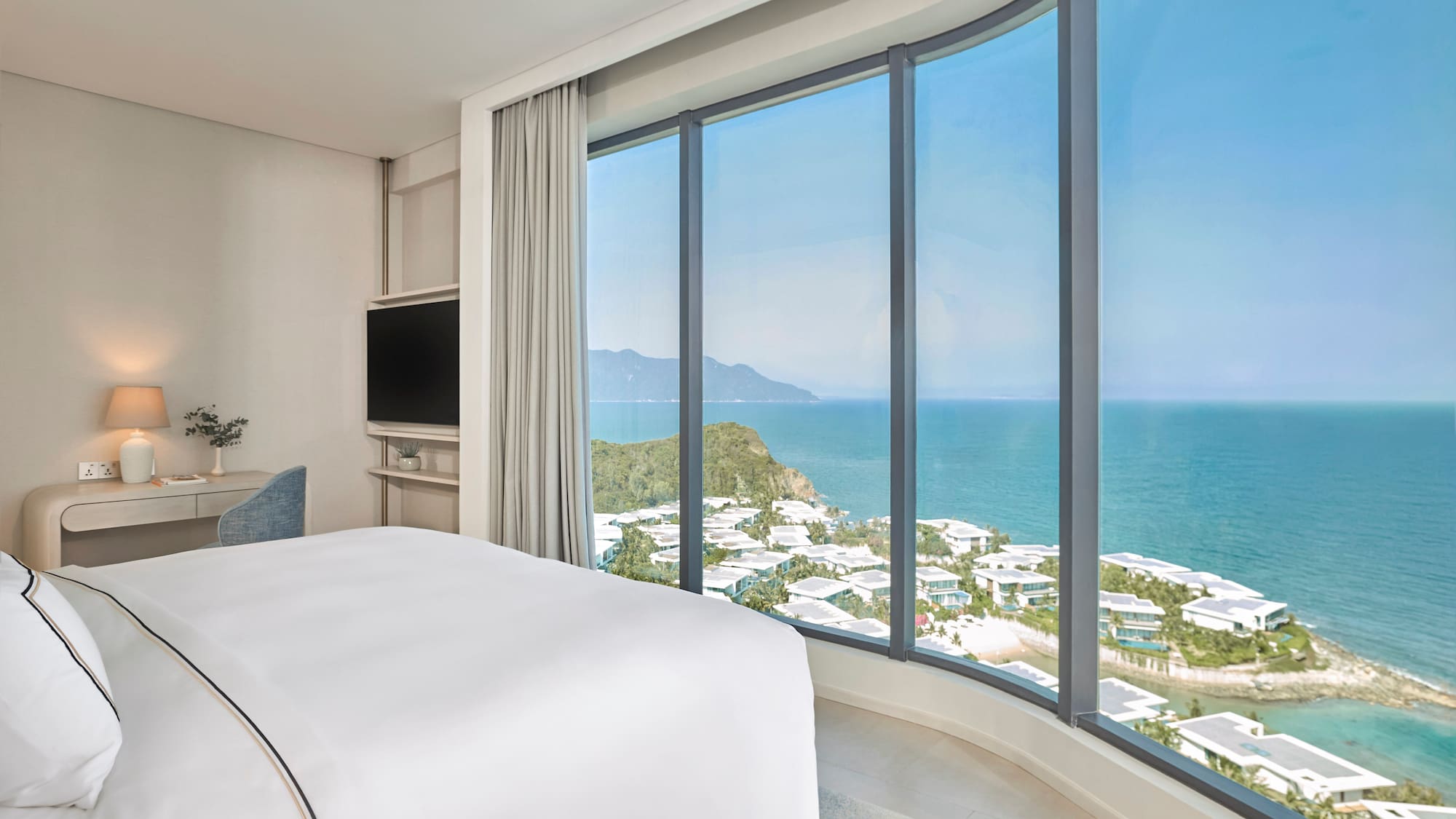 Modern hotel room with panoramic ocean and coastal resort views.