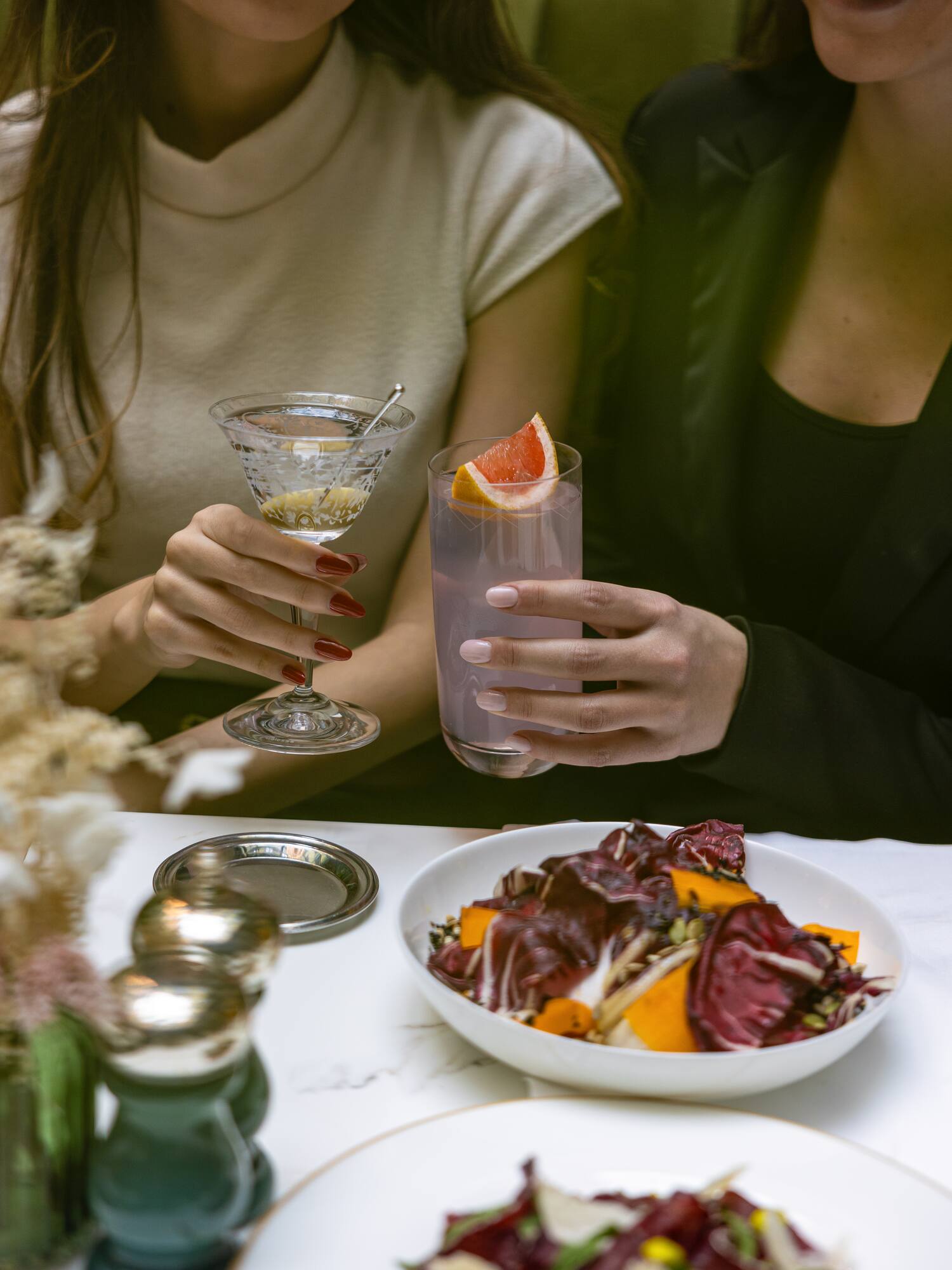 a couple of women holding drinks