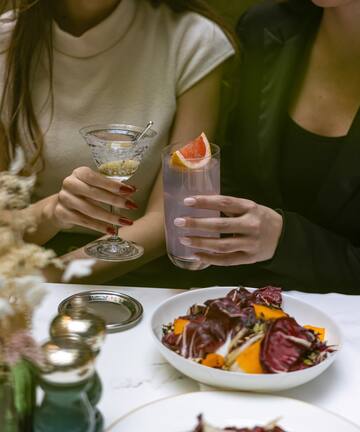 a couple of women holding drinks