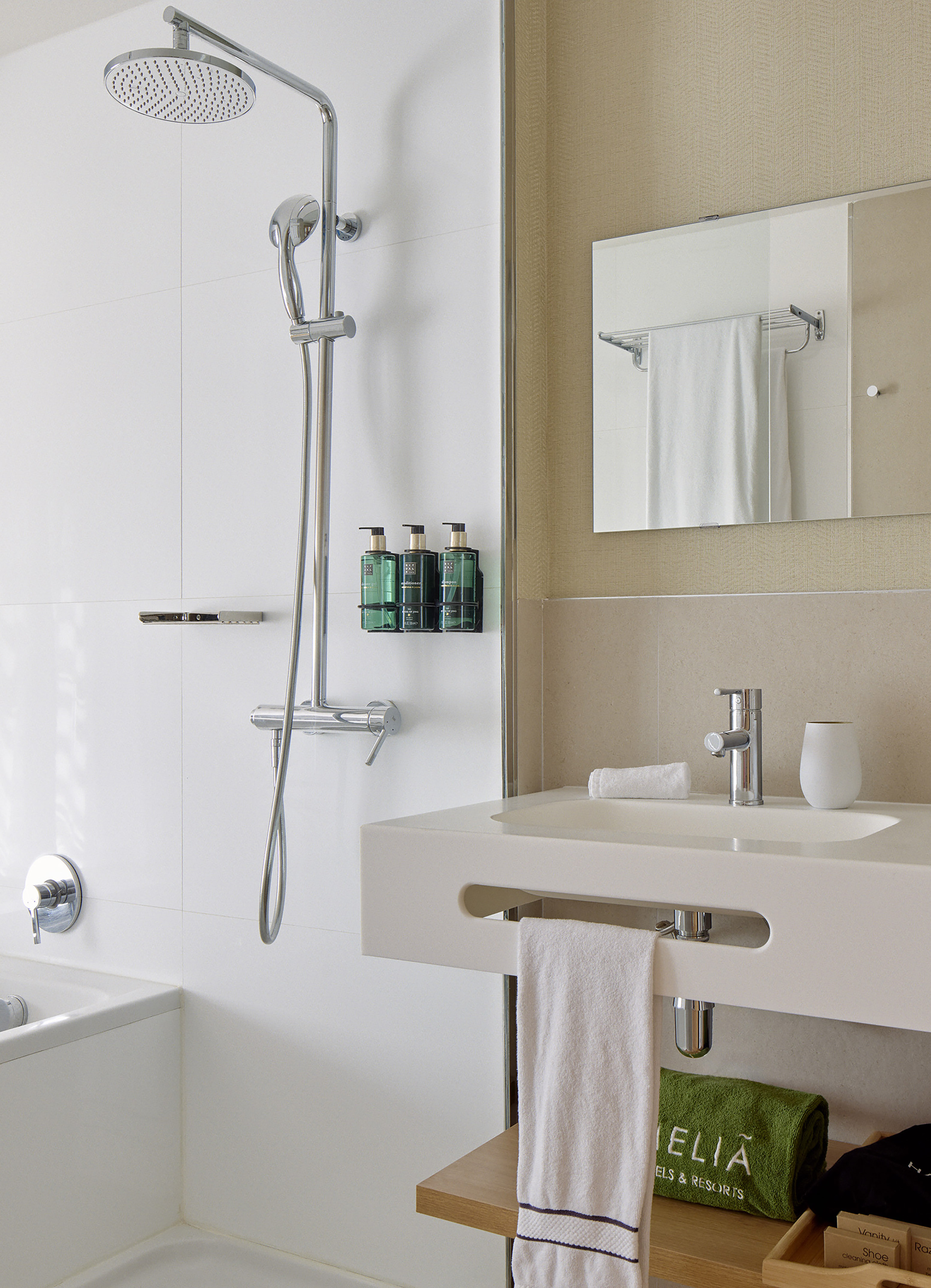 Modern Meliã hotel bathroom with rain shower, vanity sink, and branded amenities.