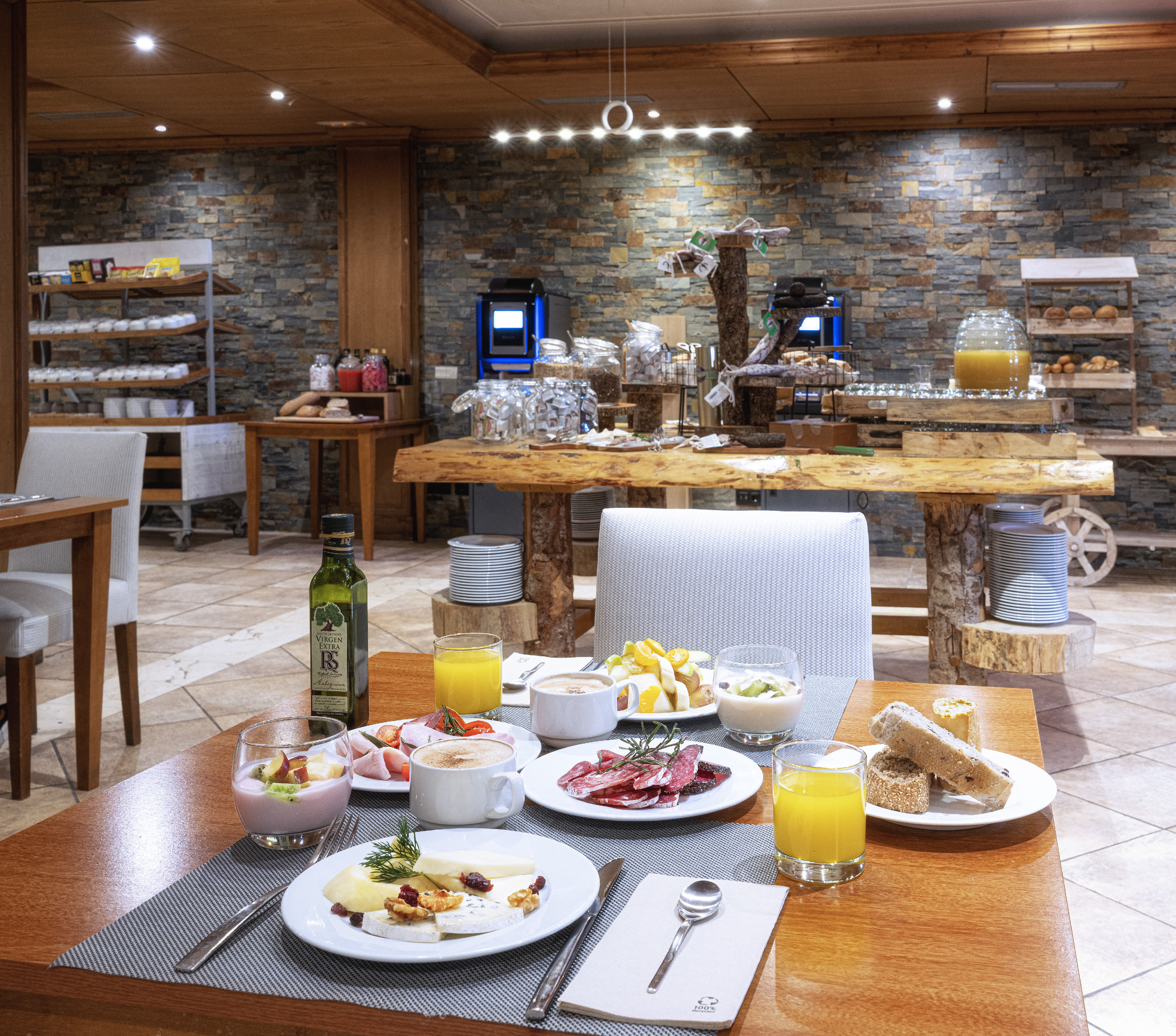 Hotel buffet breakfast with cheese, cured meats, fruit, coffee, and juice.