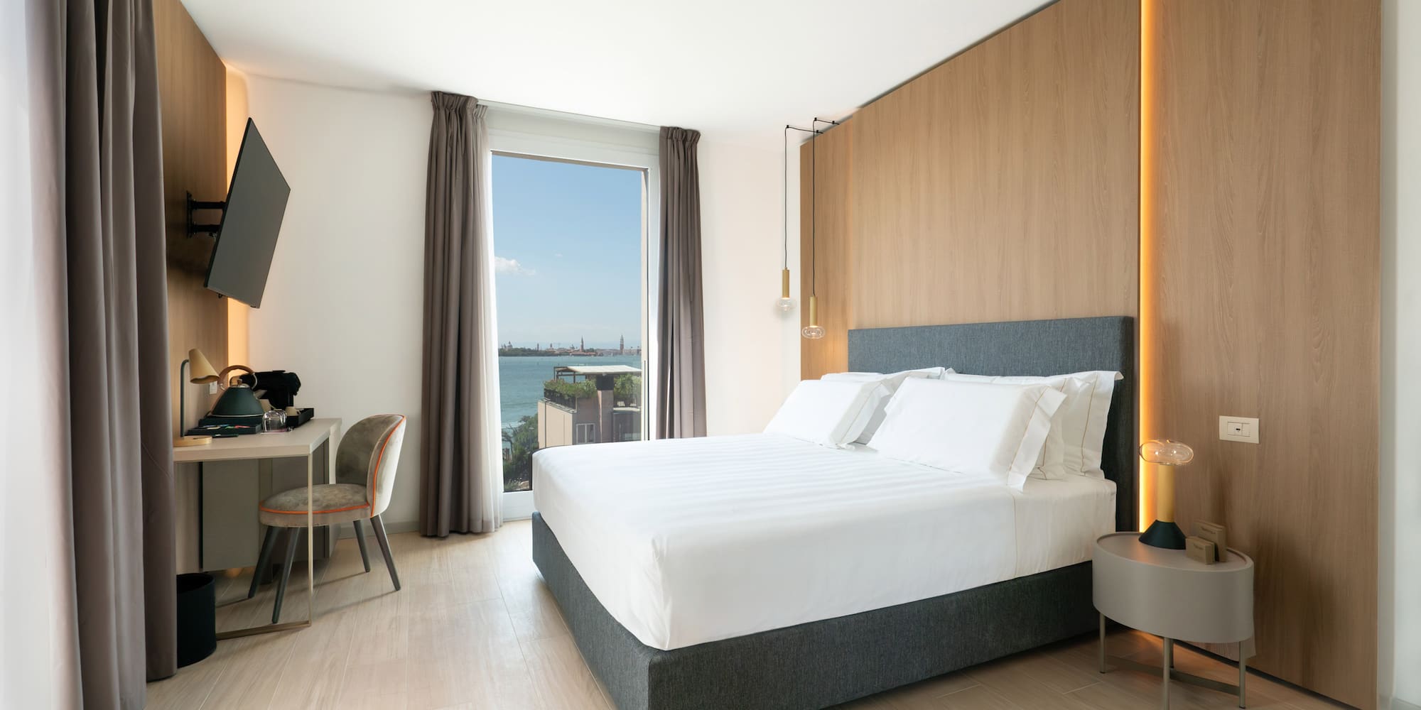 a room with a bed and a desk and a television