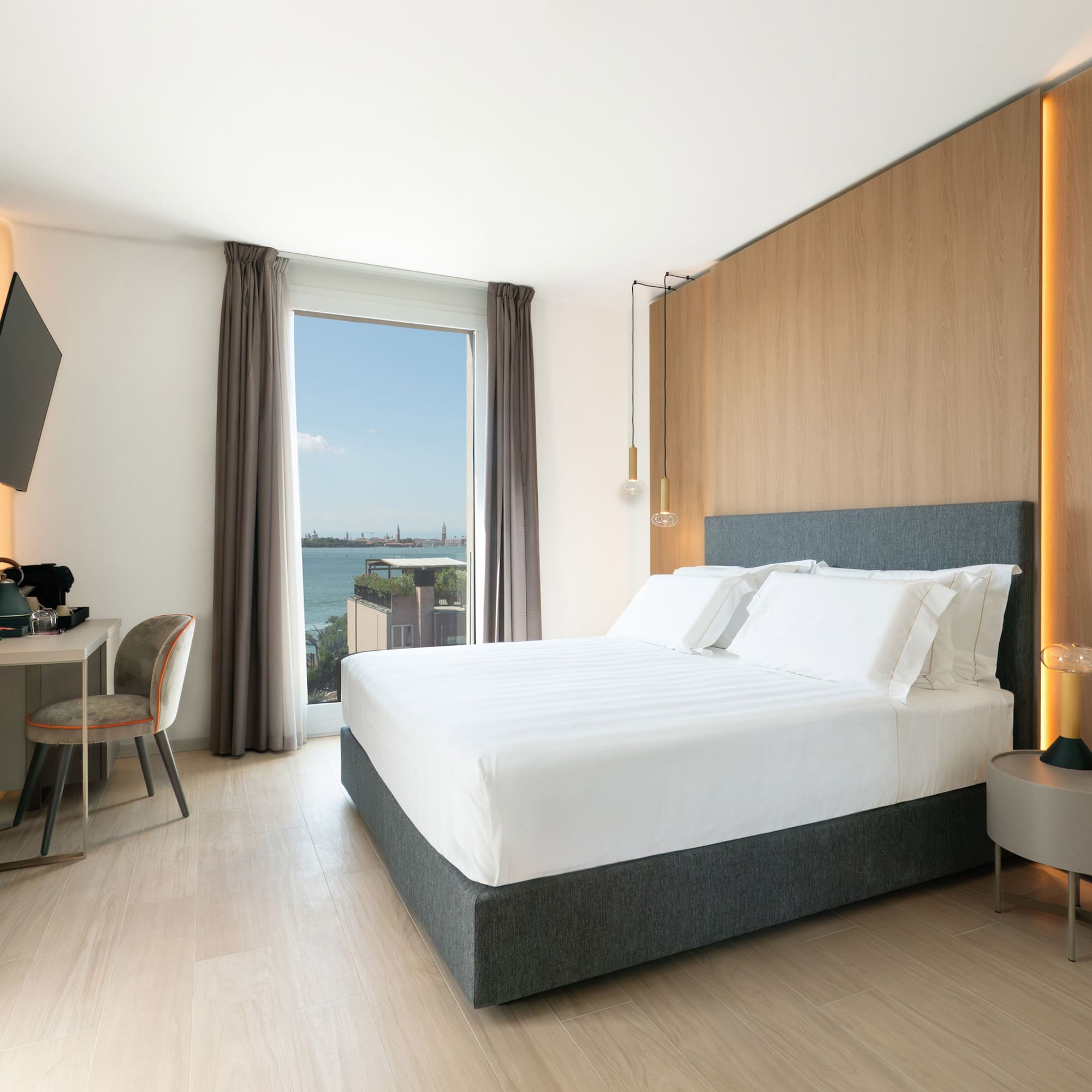 a room with a bed and a desk and a television