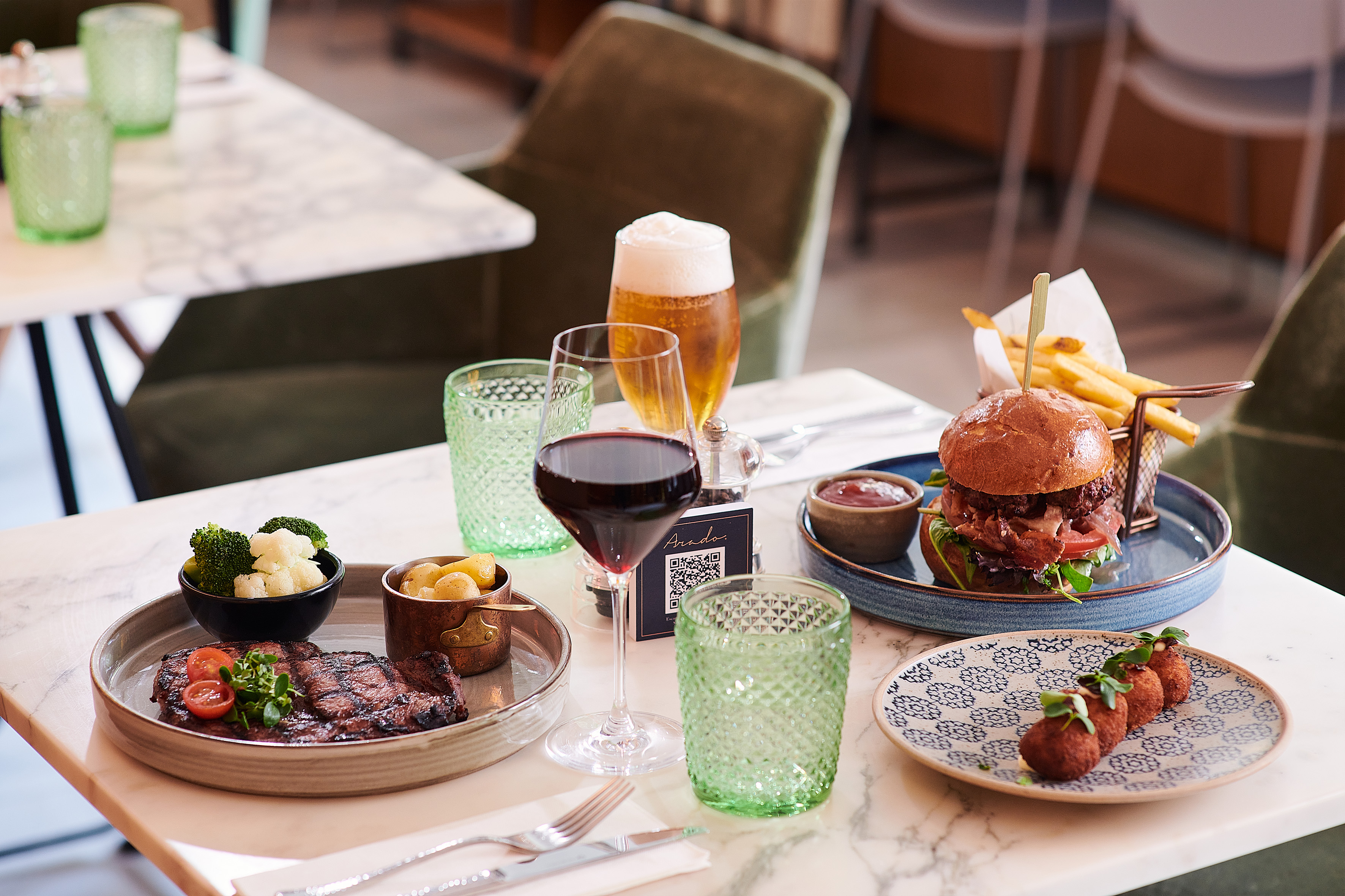 Platos de restaurante: bistec, hamburguesa, croquetas, vino y cerveza.