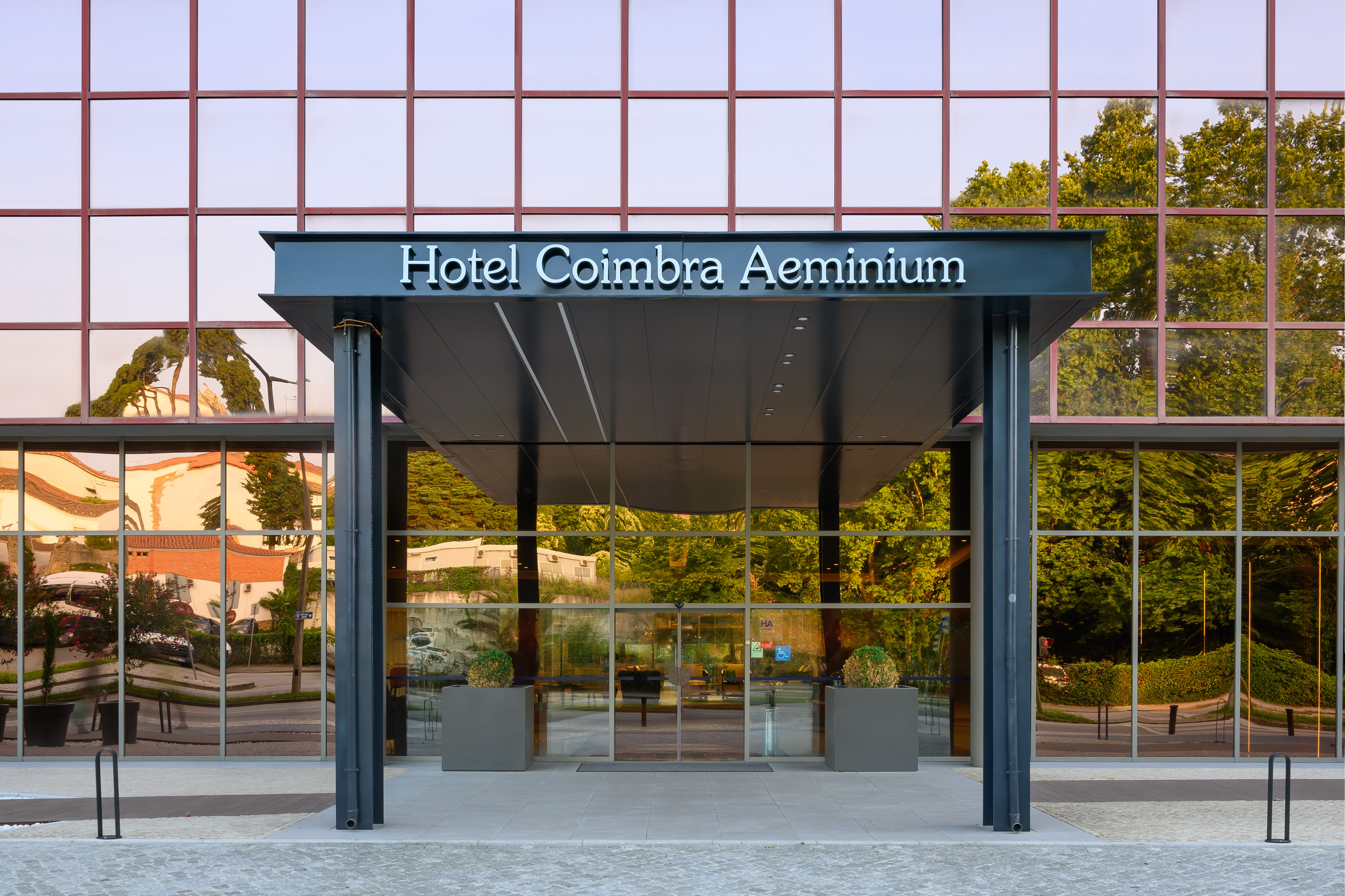 Hotel Coimbra Aeminium entrance, modern glass facade.