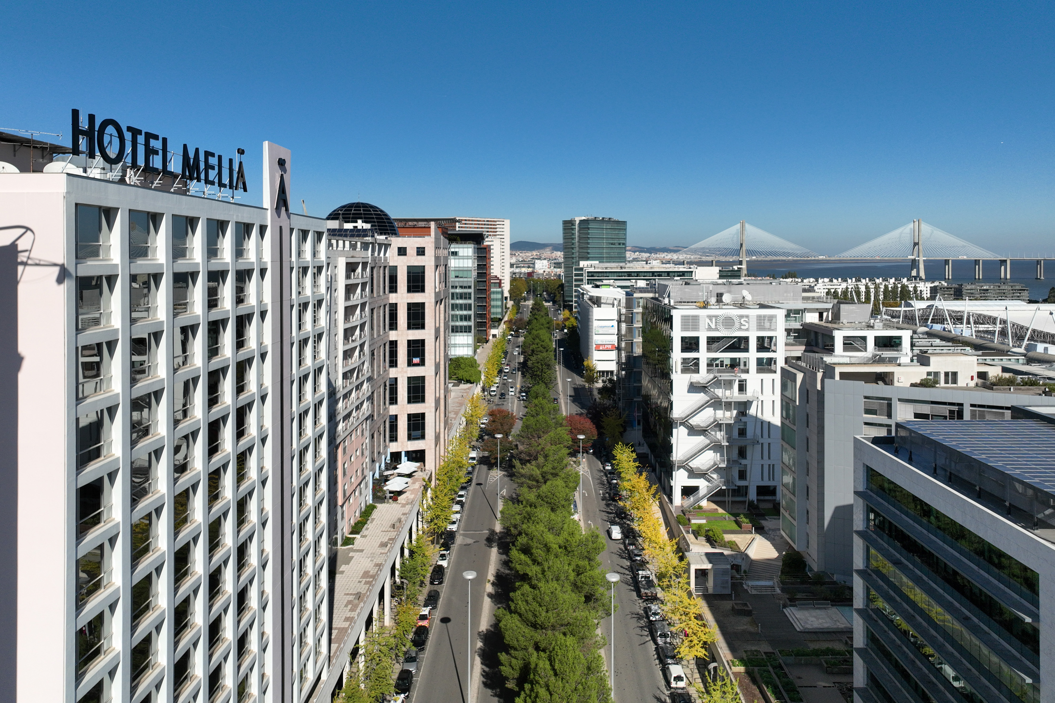 Hotel Melia, modern Lisbon avenue, buildings, and Vasco da Gama bridge.
