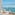 Luxury balcony lounge with panoramic ocean views and distant island.