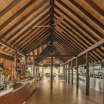 a room with a wood ceiling and a table with food on it