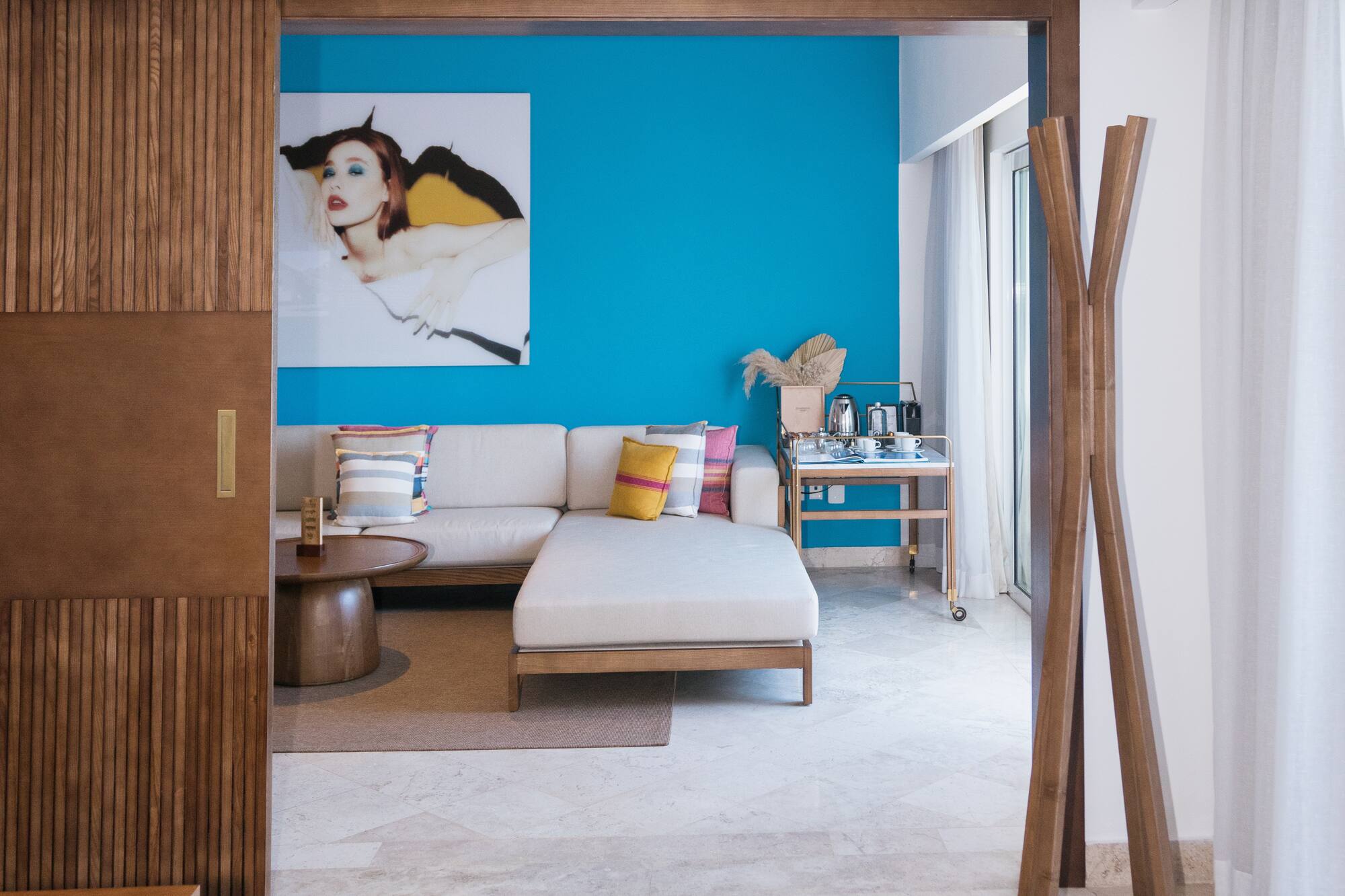 Modern living room interior with blue accent wall, L-shaped sofa, and stylish decor.