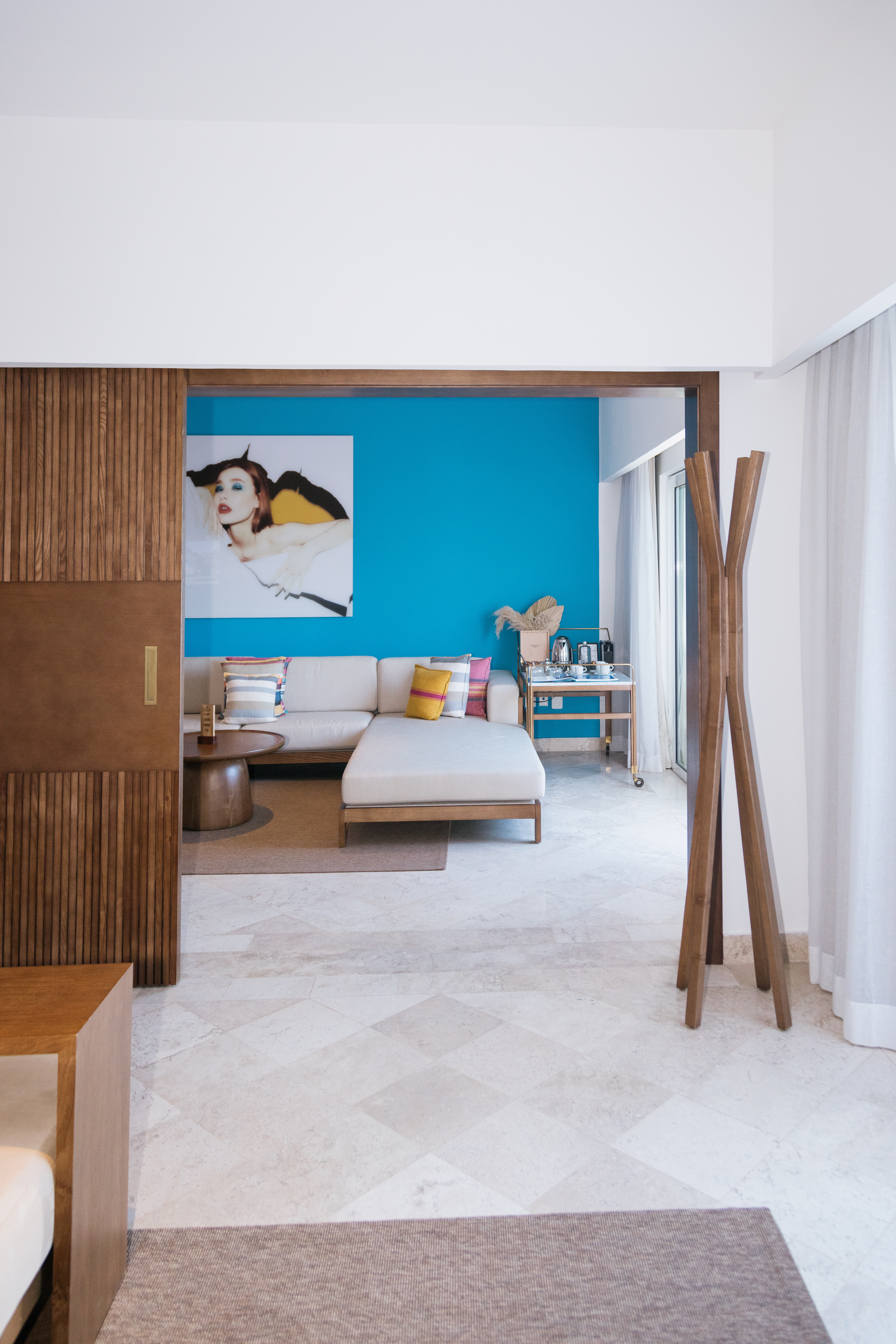 Modern living room interior with blue accent wall, L-shaped sofa, and stylish decor.
