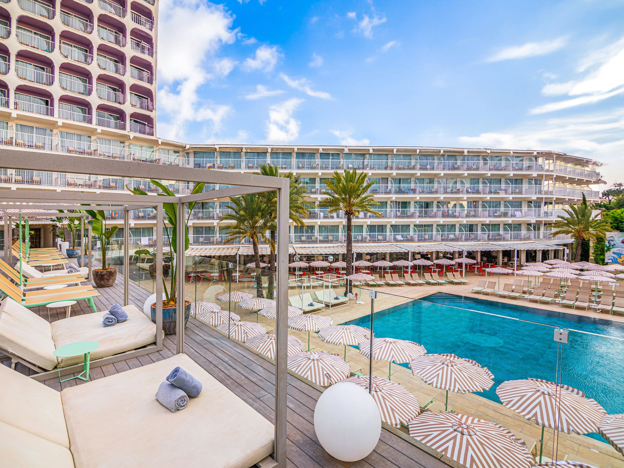 a pool with umbrellas and lounge chairs