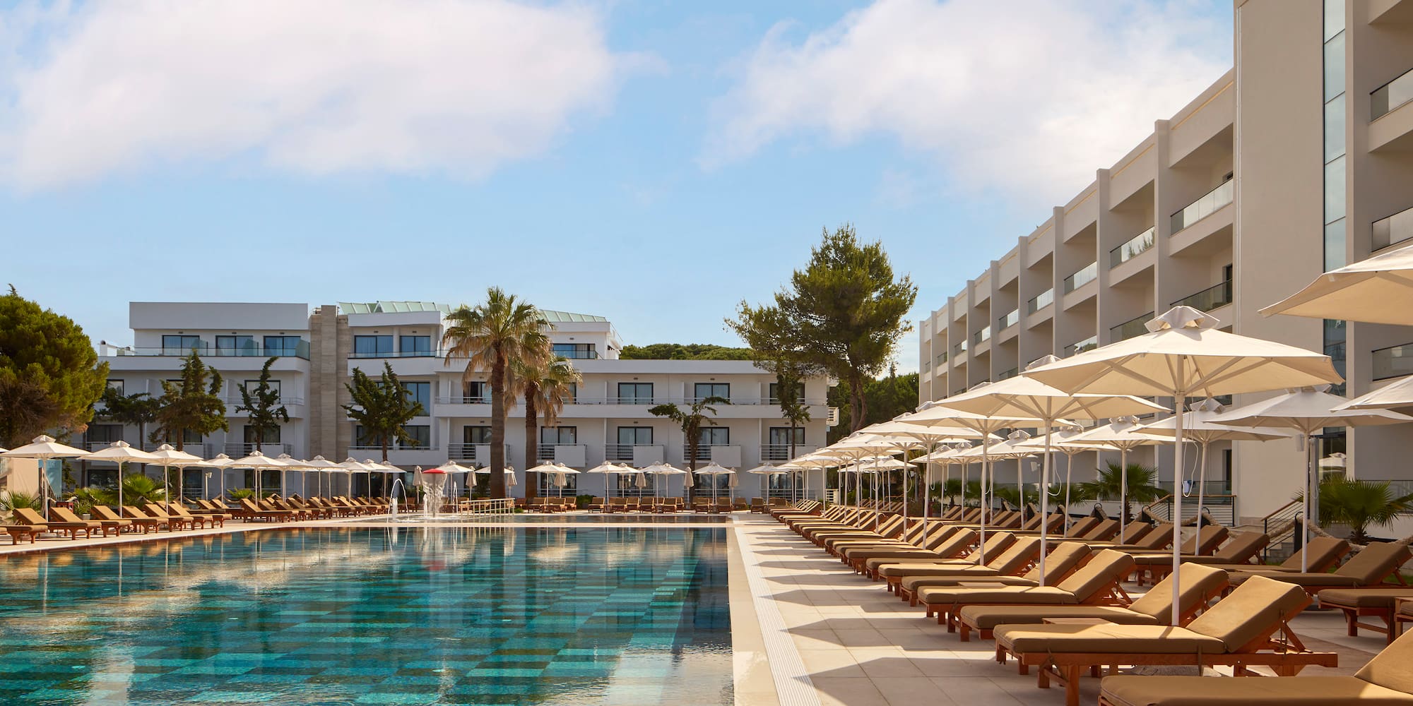 a pool with lounge chairs and umbrellas