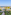 Resort con piscinas, toboganes acuáticos, palmeras, jardines y mar azul.