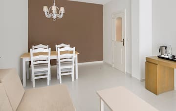 a dining room with white chairs and a chandelier