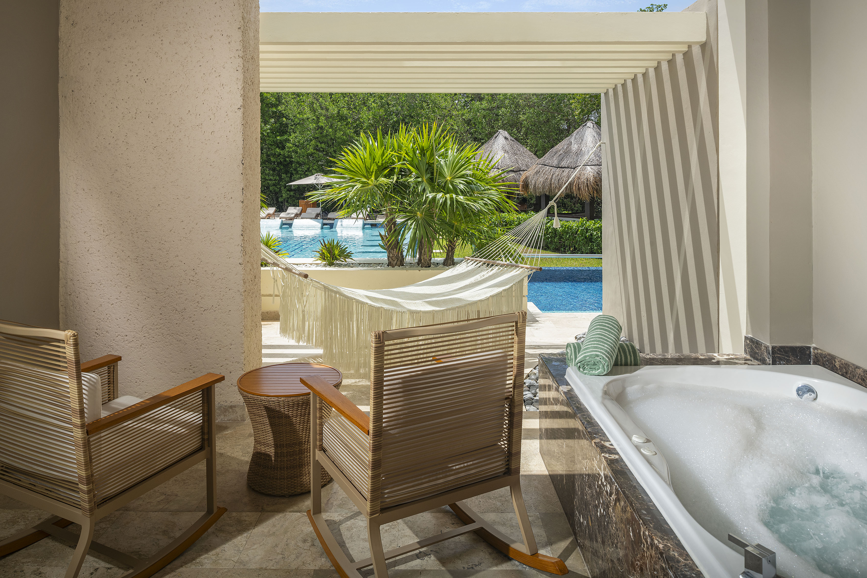 a chair and a bathtub next to a pool
