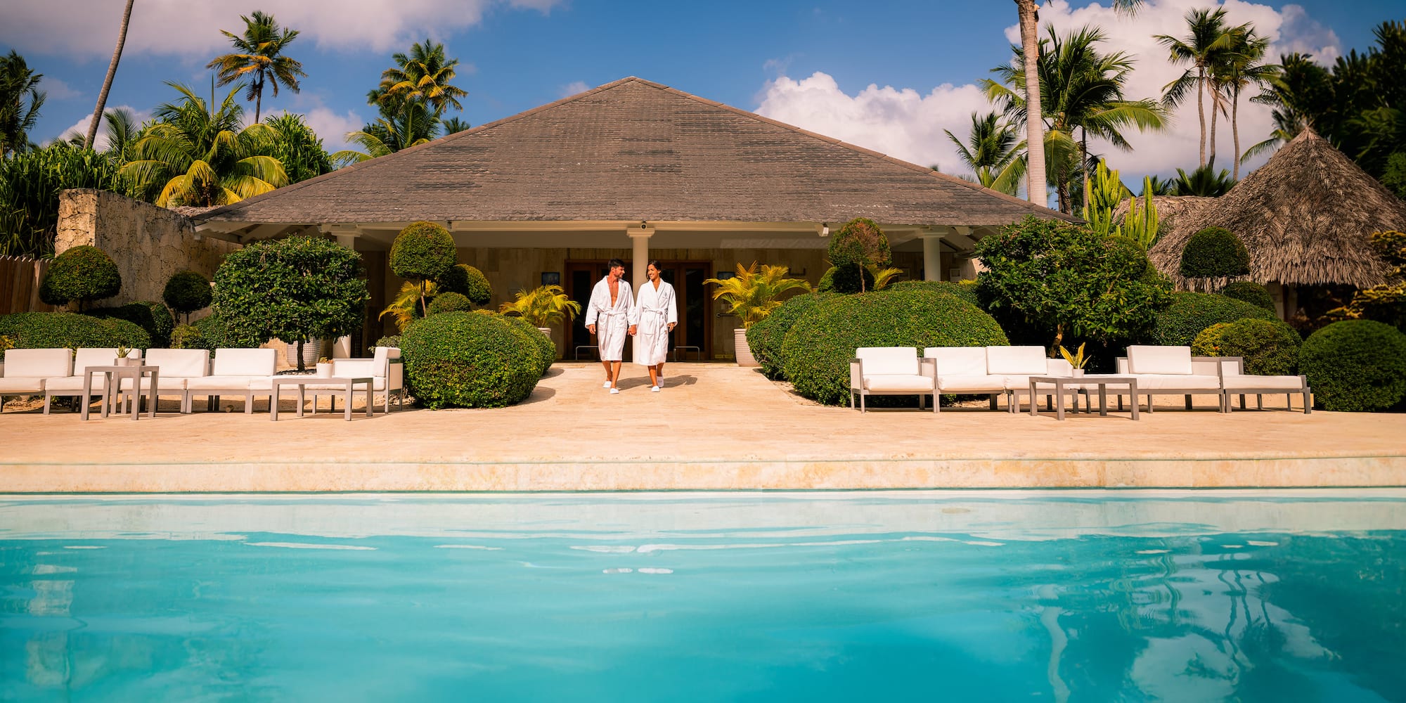 two people standing in front of a pool